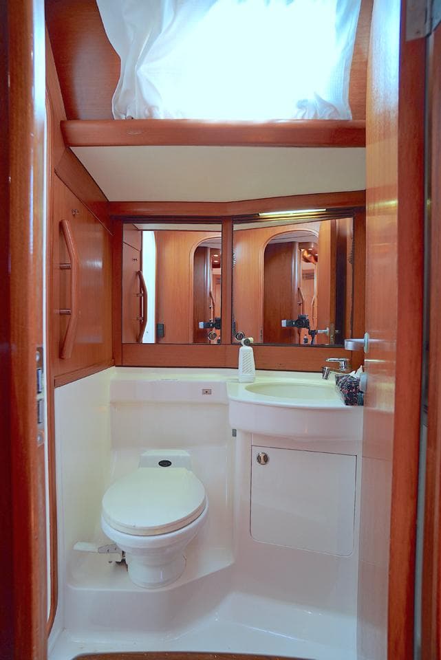 Luxurious bathroom in a 1995 Nautor Swan 60 yacht, featuring wooden cabinetry and modern fixtures.
