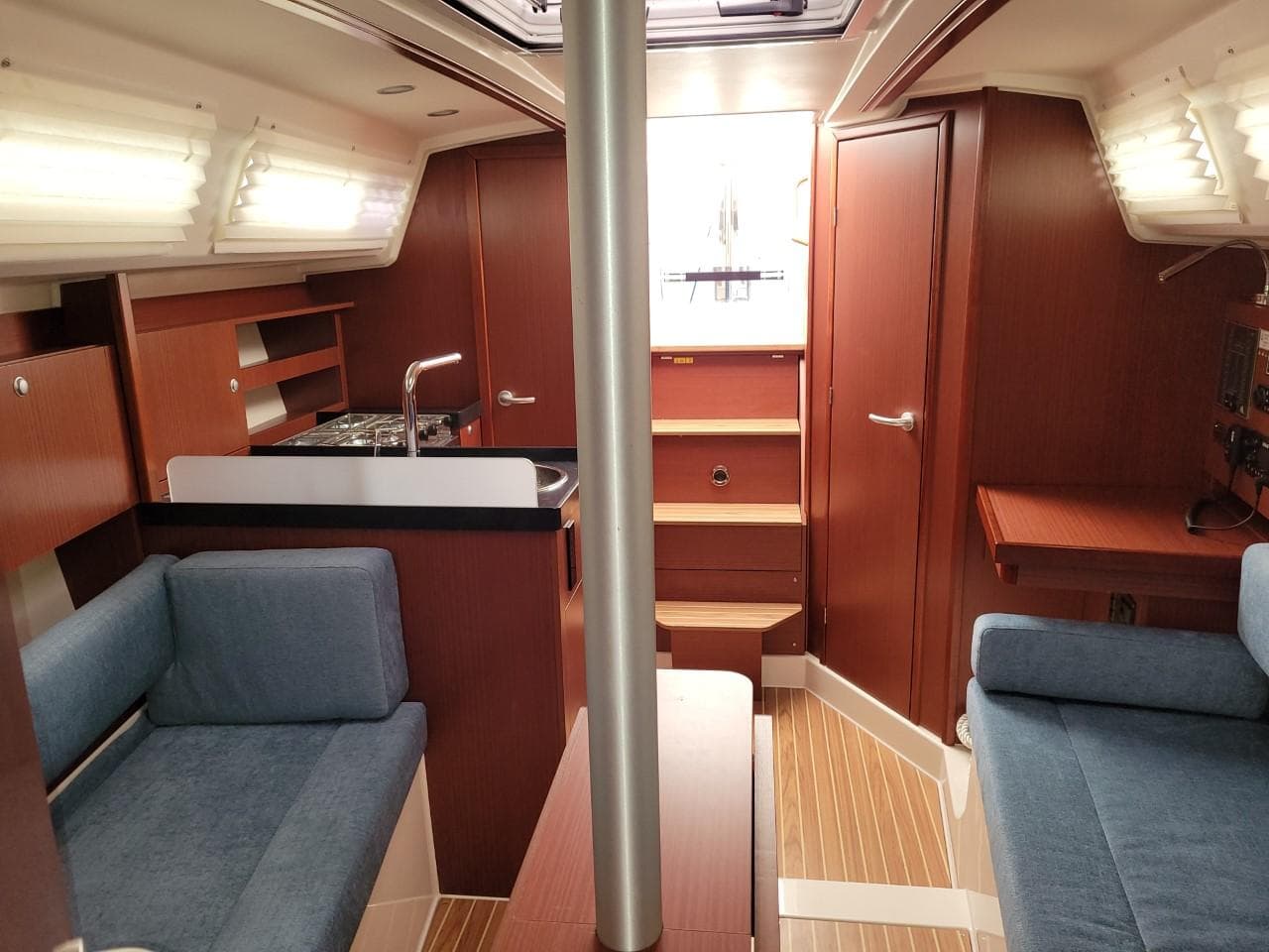 Interior of 2023 Hanse 315 sailboat with modern wood finish and blue seating.
