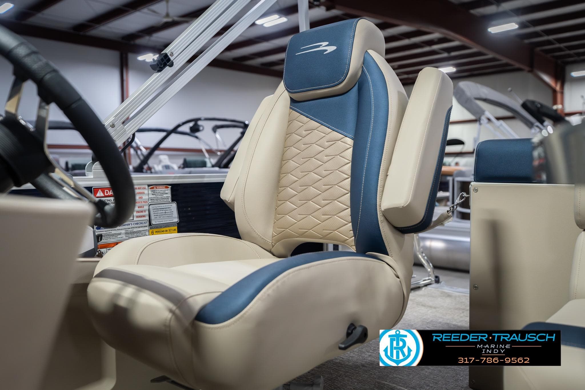 2026 Bennington 168 SLJ boat seat with blue and beige upholstery in showroom.