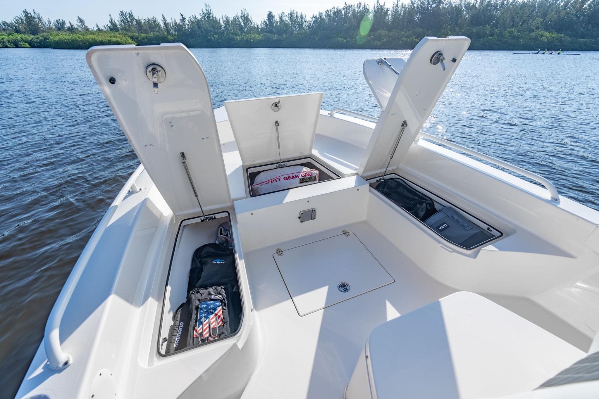 Manufacturer Provided Image: 2026 Pathfinder 2600 TRS boat with open storage compartments on a serene lake.