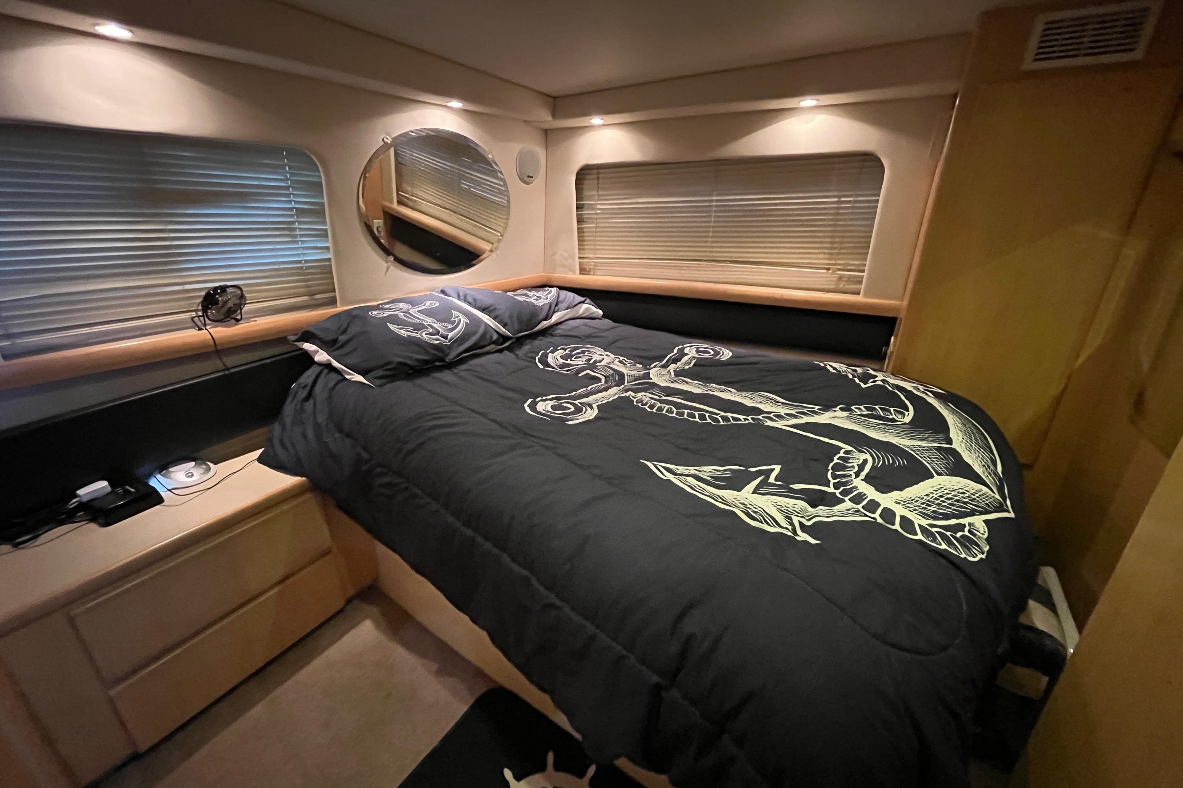 Cozy bedroom in 1996 Carver 355 Aft Cabin Motor Yacht with nautical-themed bedding.