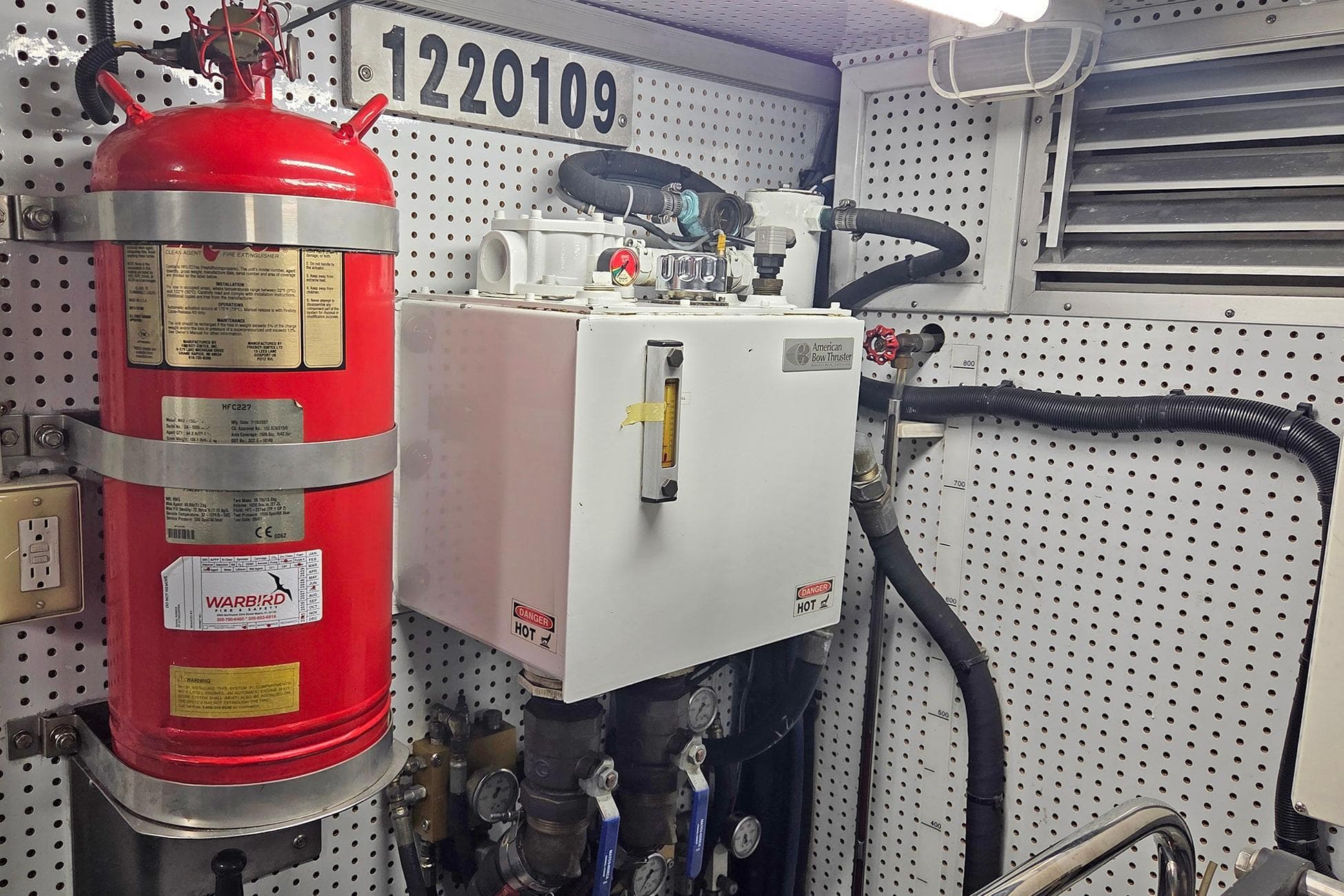 Engine room of 2008 Outer Reef Yachts 650 Motoryacht with fire extinguisher and equipment.