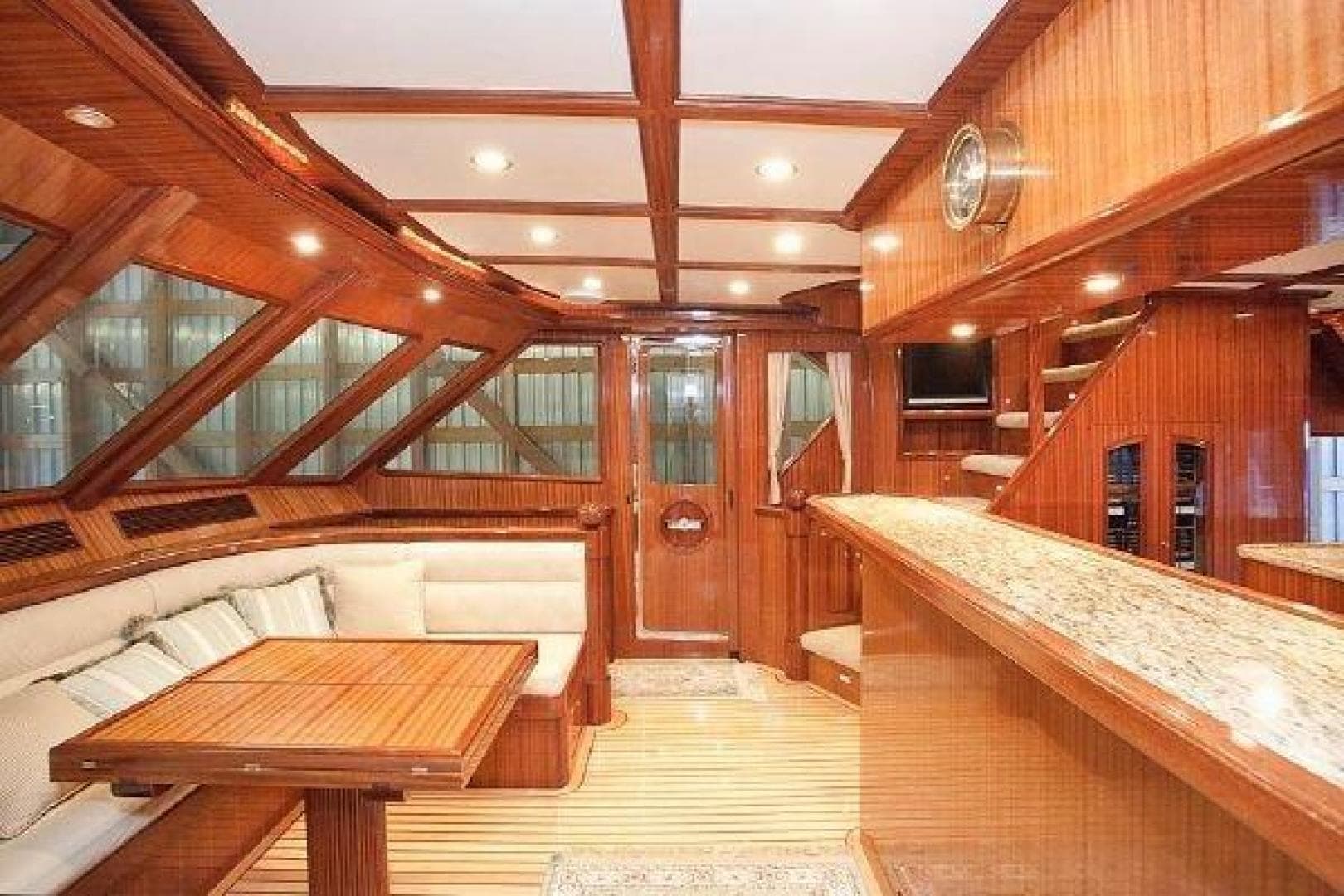 Luxurious interior of 2027 Legend Boats 630 Skylounge with wood finish and elegant seating.
