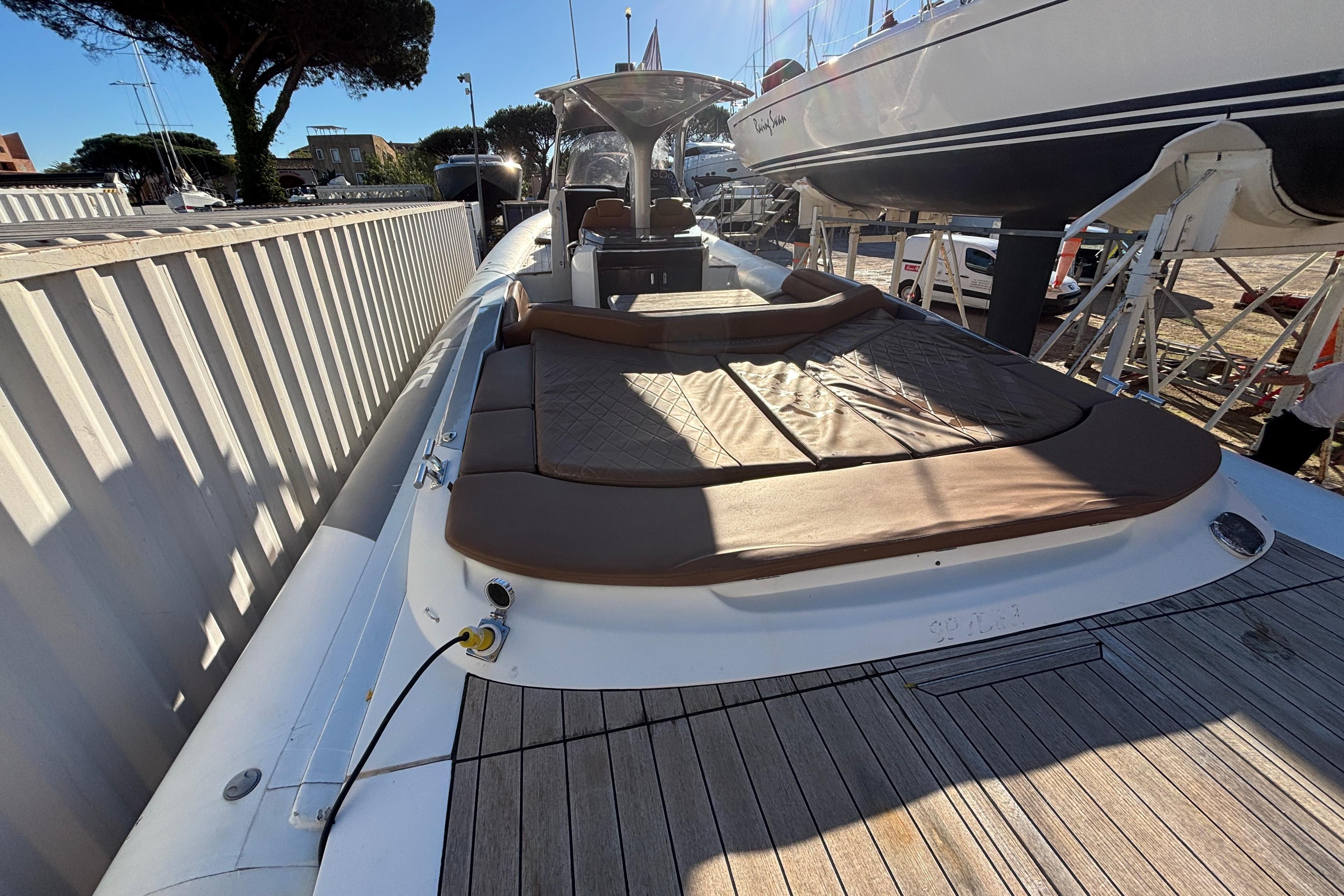 2015 SACS Strider 13 luxury yacht with sunbathing deck, docked in marina.