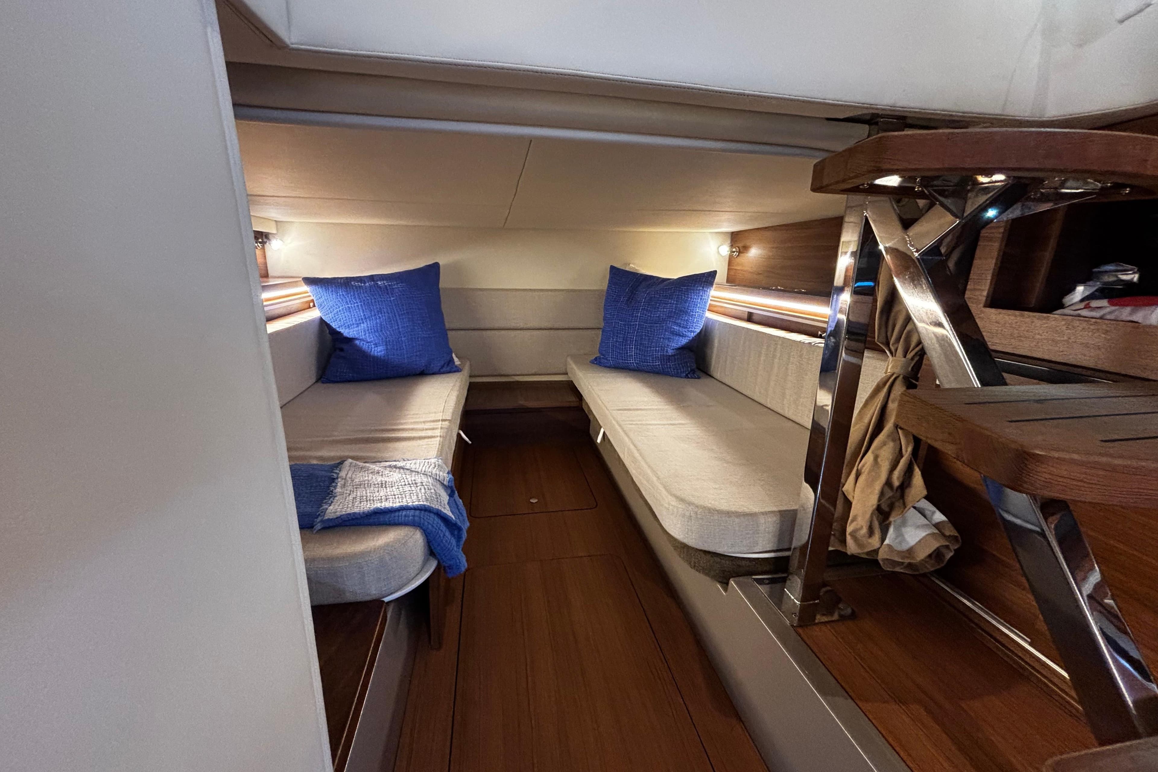 Interior cabin of 2022 Sea Ray Sundancer 320 with twin beds and blue cushions.