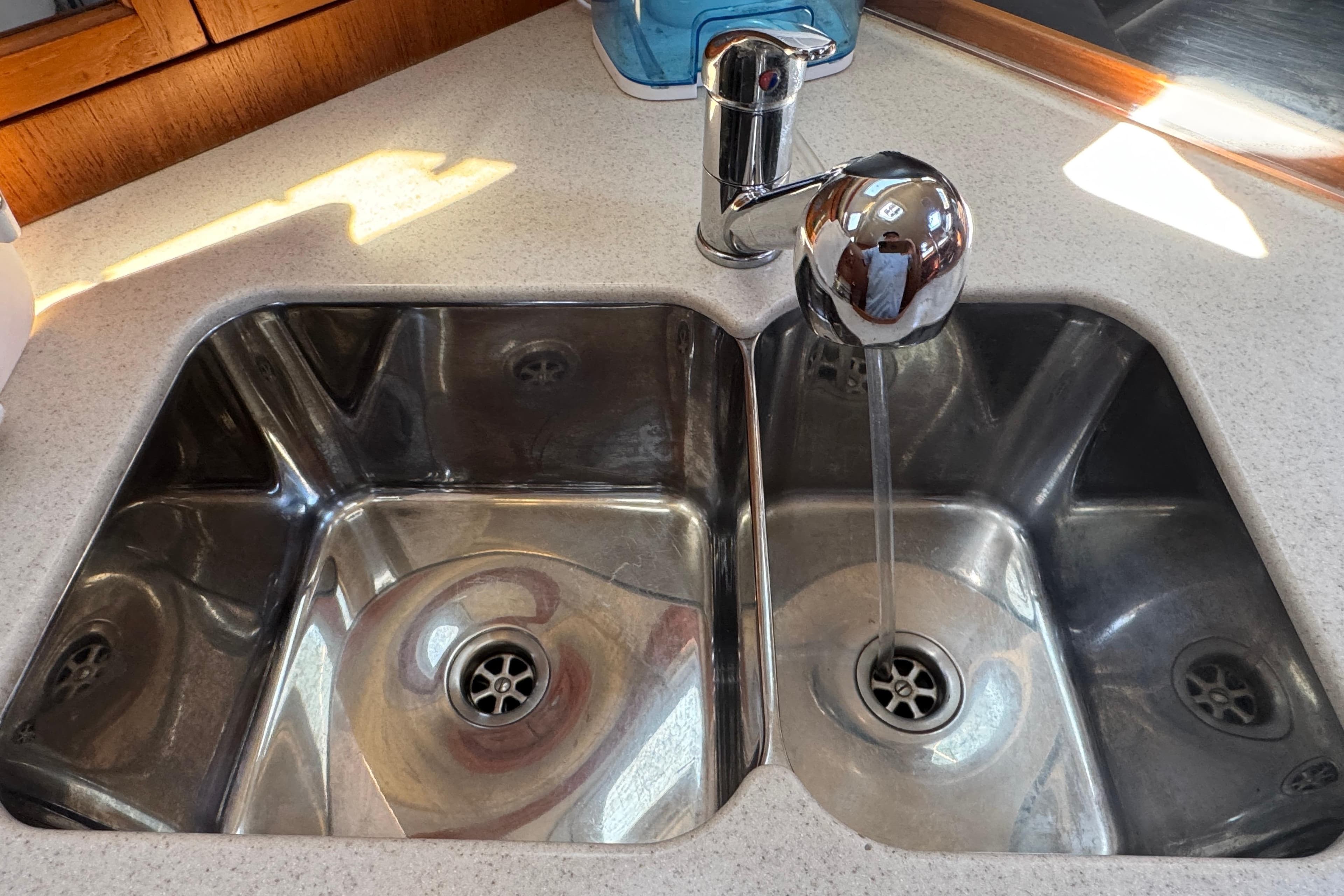 Stainless steel double sink with running water in a 2004 Hunter 41 Aft Cockpit yacht.