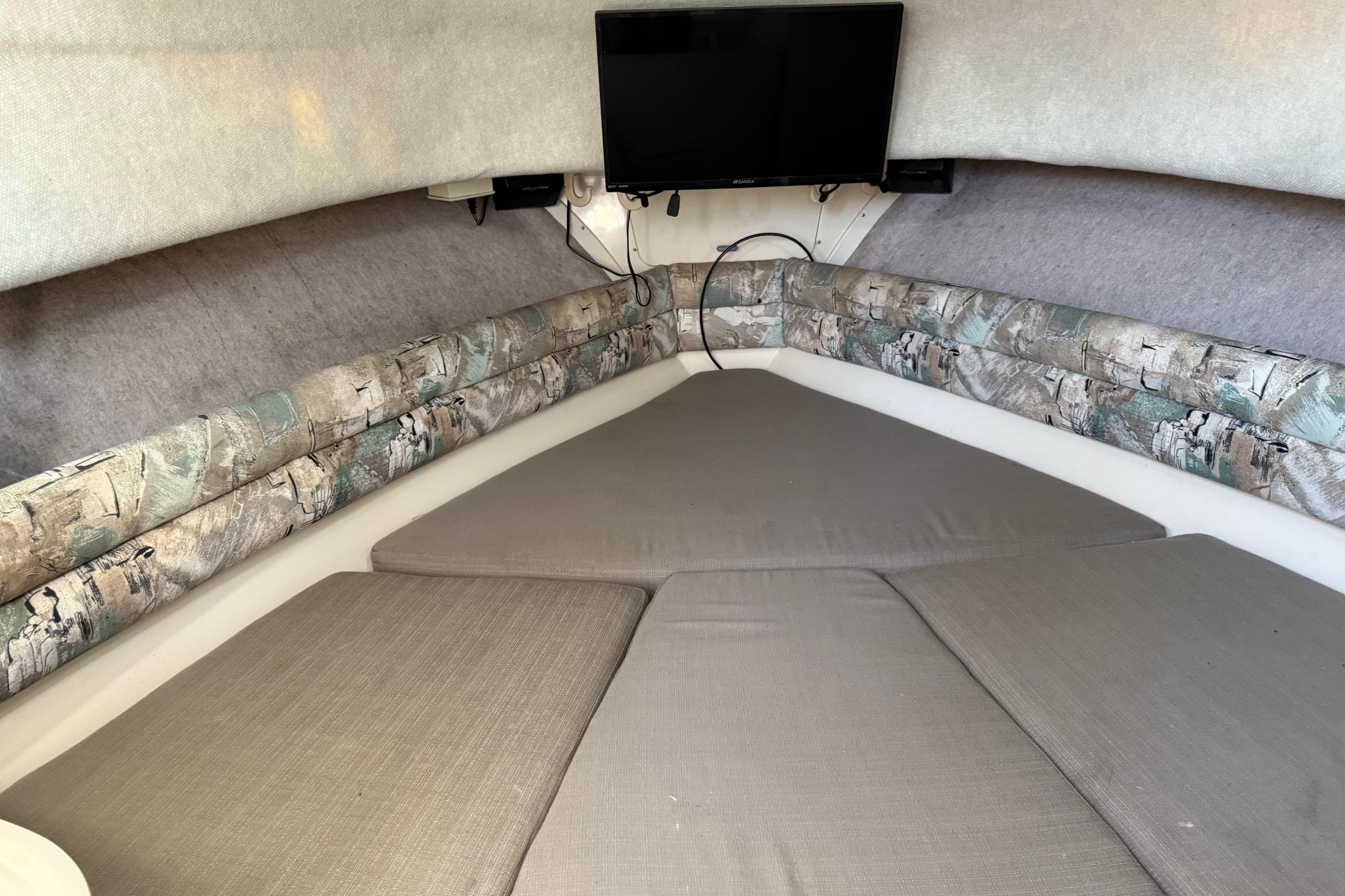 Interior cabin of 1996 Grady-White Marlin 300 with cushions and mounted TV.