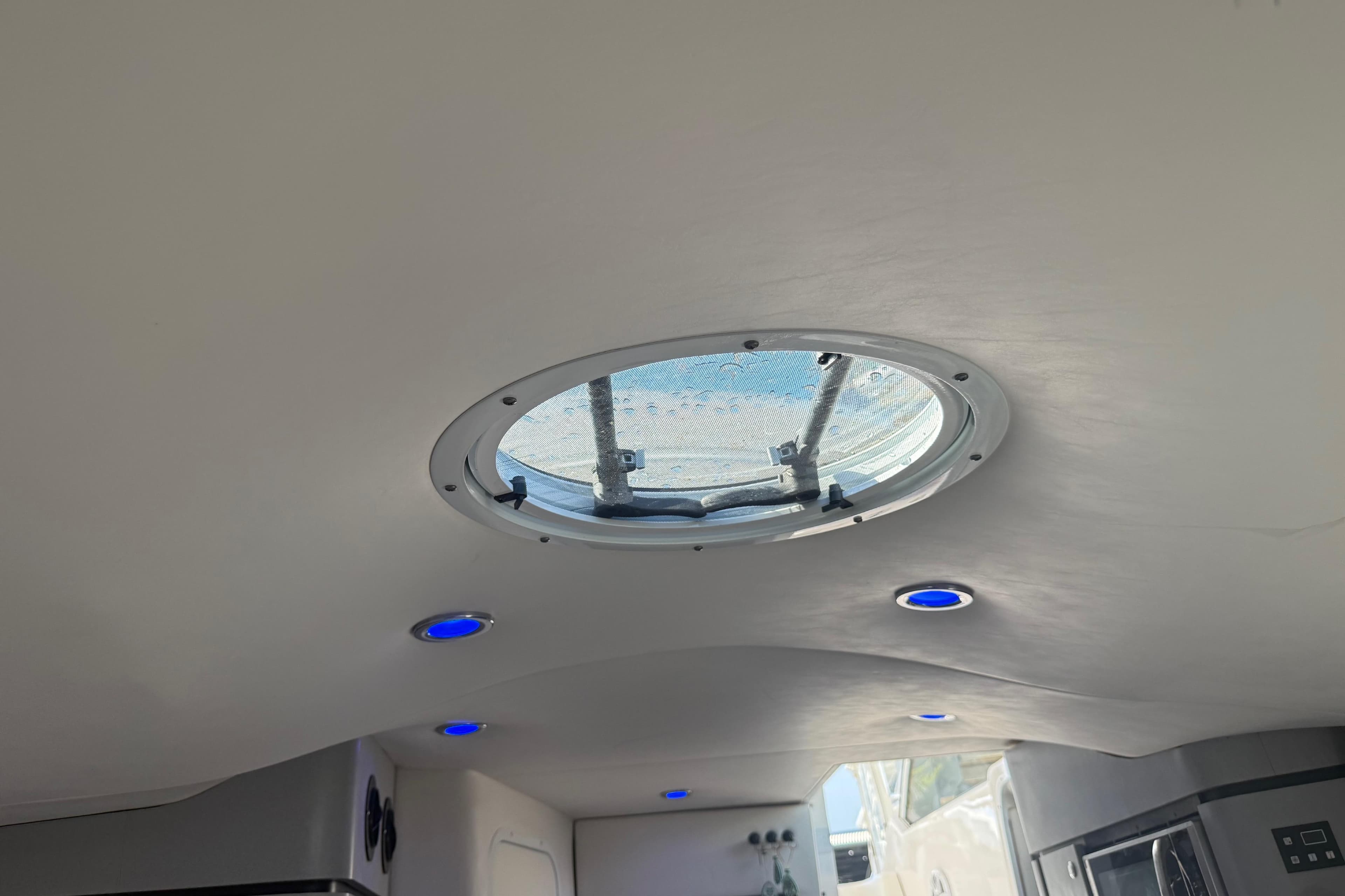 Ceiling view of 2017 Fountain 38 Sportfish Cruiser with round hatch and blue LED lights.