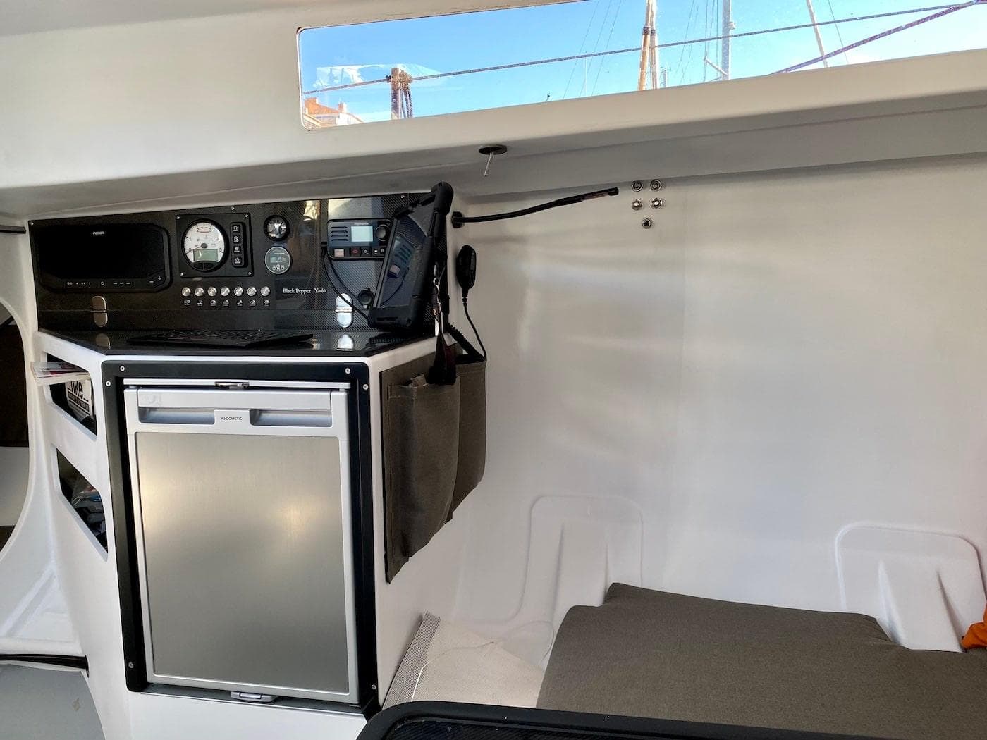 Interior of Black Pepper Code 0.1 yacht, featuring navigation equipment and compact fridge, 2025 model.