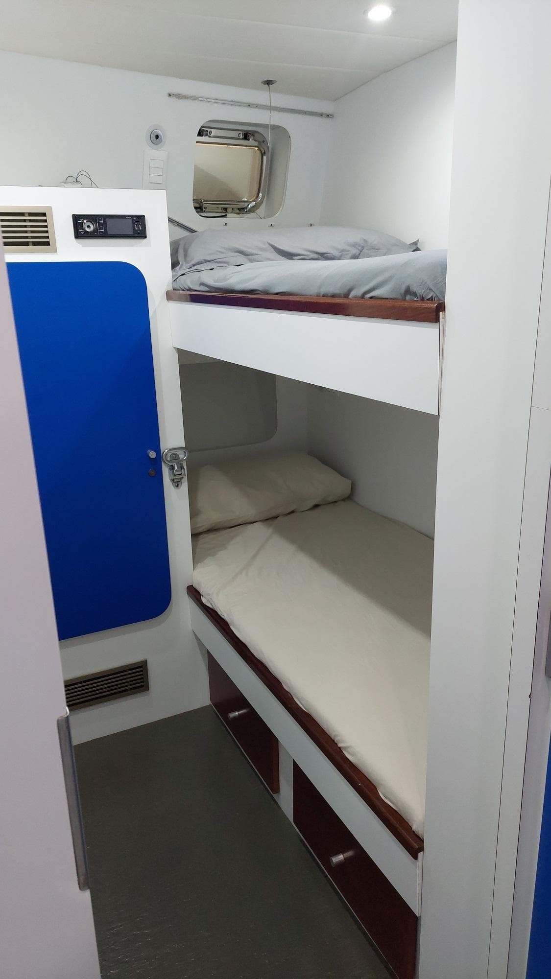 Bunk beds in a 1992 Admiral 28 boat cabin with blue accents.