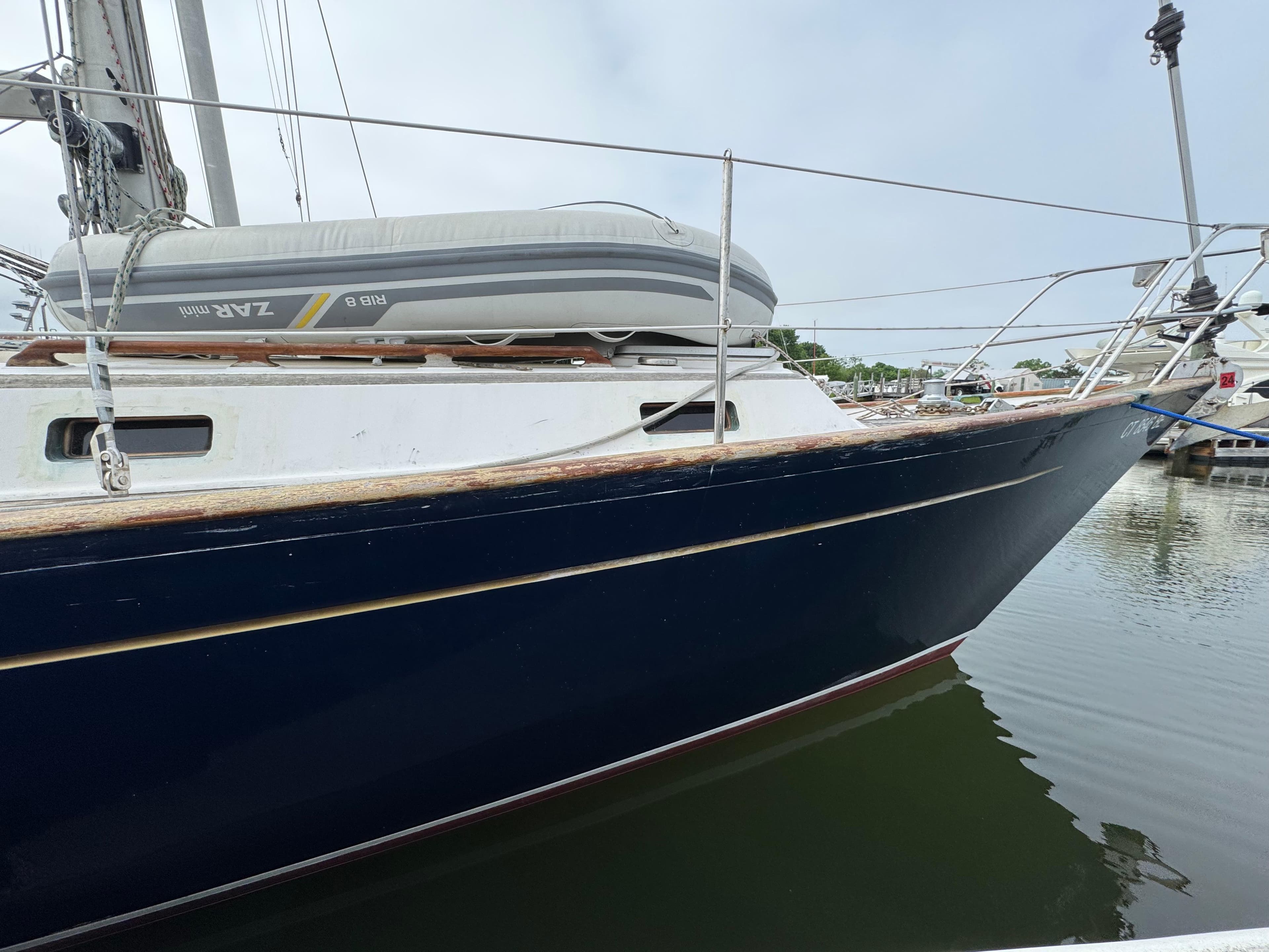 1982 Passport 40 sailboat with dinghy, docked in calm waters.