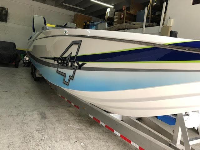 2006 MTI 44 Pleasure Cat boat in storage, featuring sleek design and bold graphics.