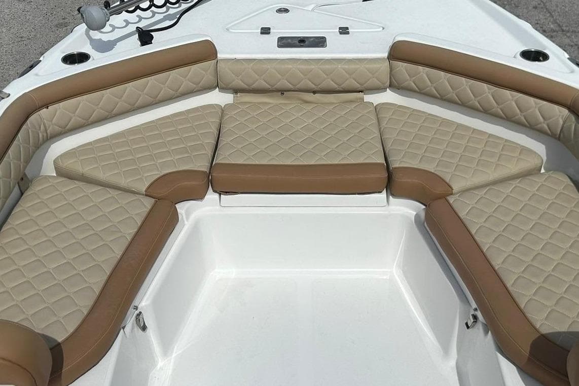 2024 NauticStar 211 Hybrid boat with tan cushioned seating and modern design.