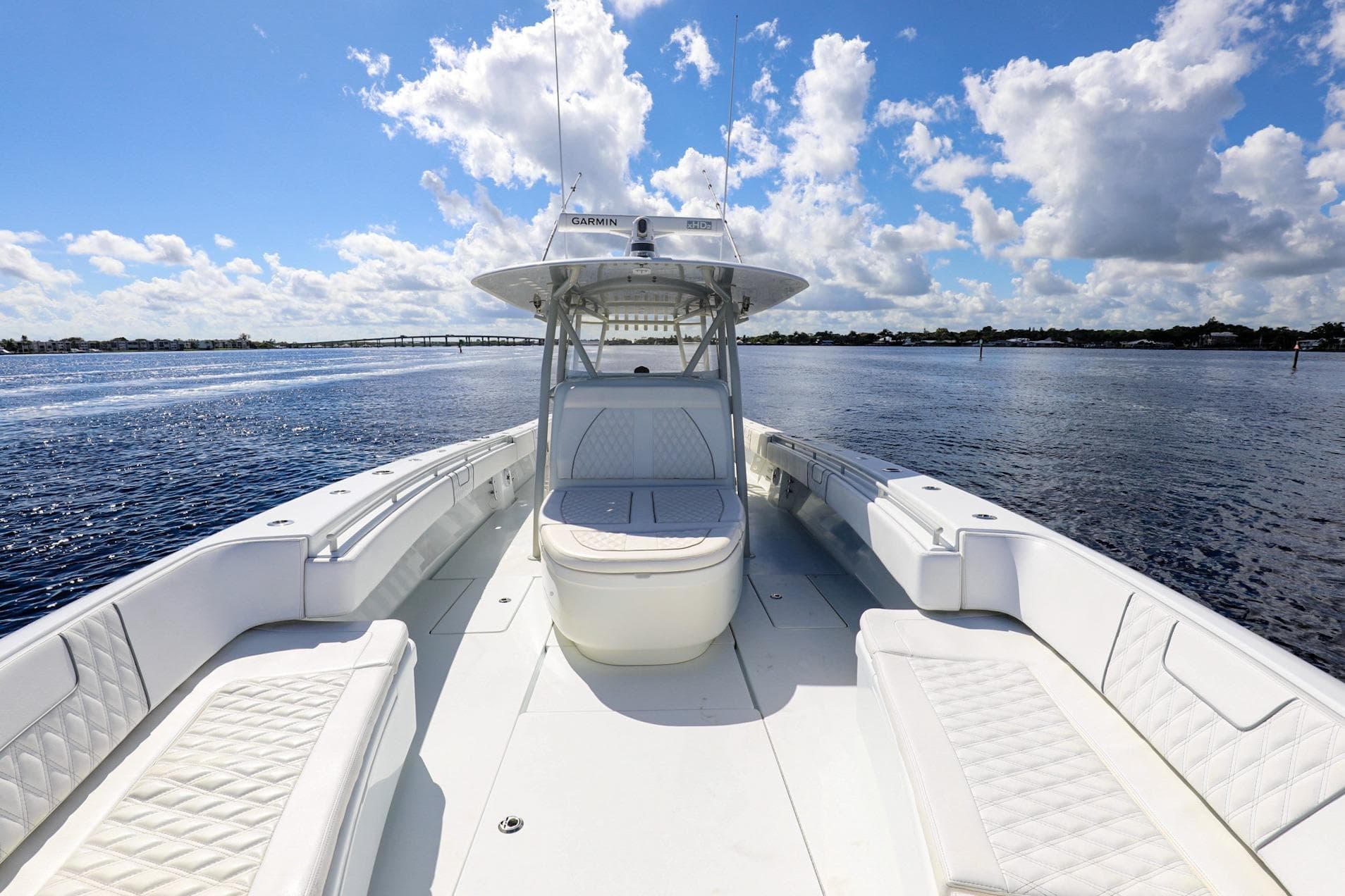 2023 Contender 44 ST boat on open water under a blue sky with clouds.