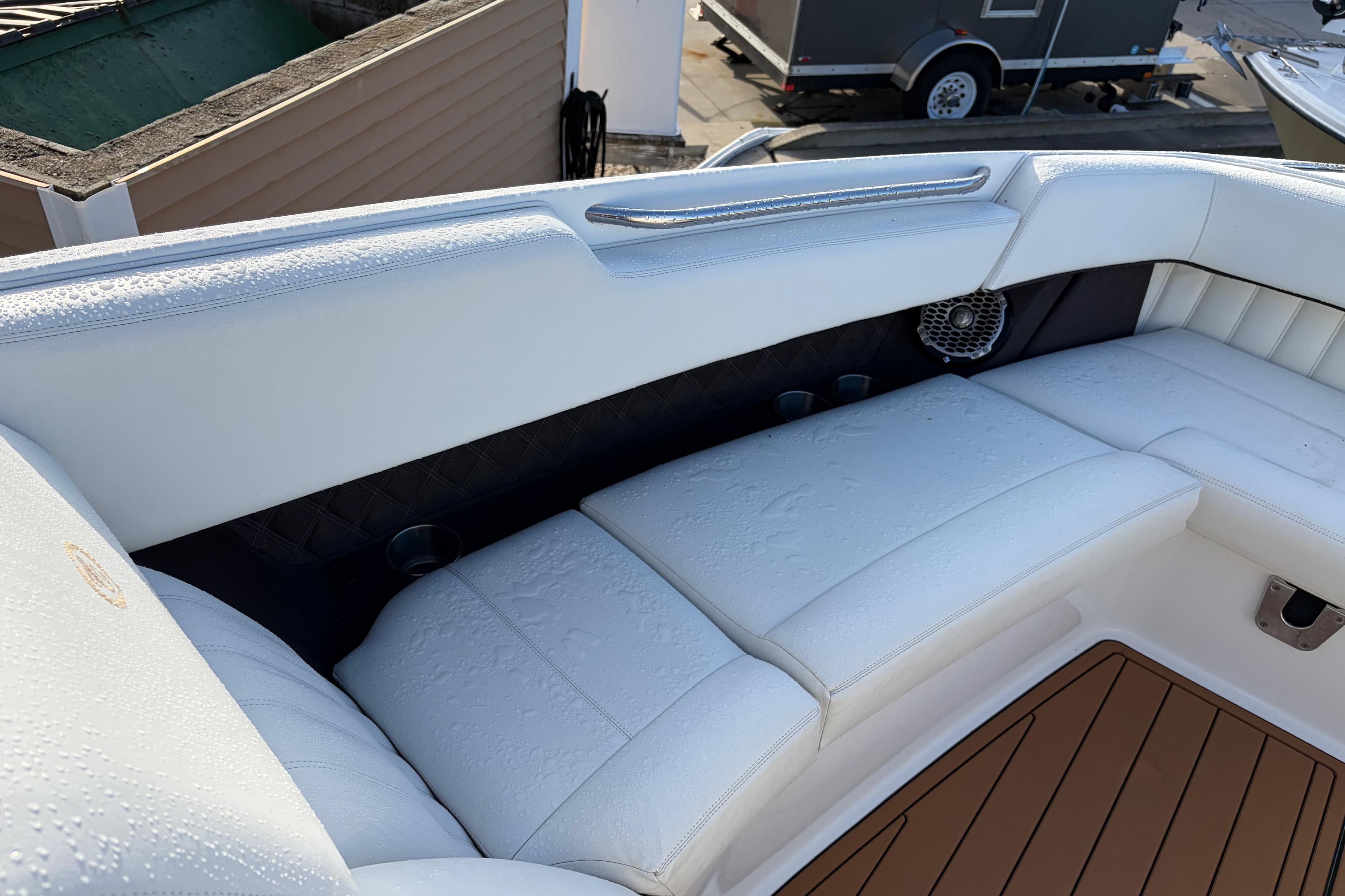 Luxurious seating on a 2015 Cobalt 336 boat, featuring white upholstery and teak flooring.