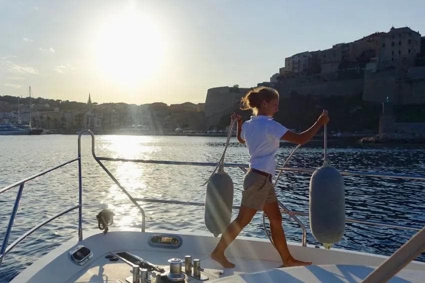 Person on Princess 61 yacht at sunset, 2001 model, near coastal town.
