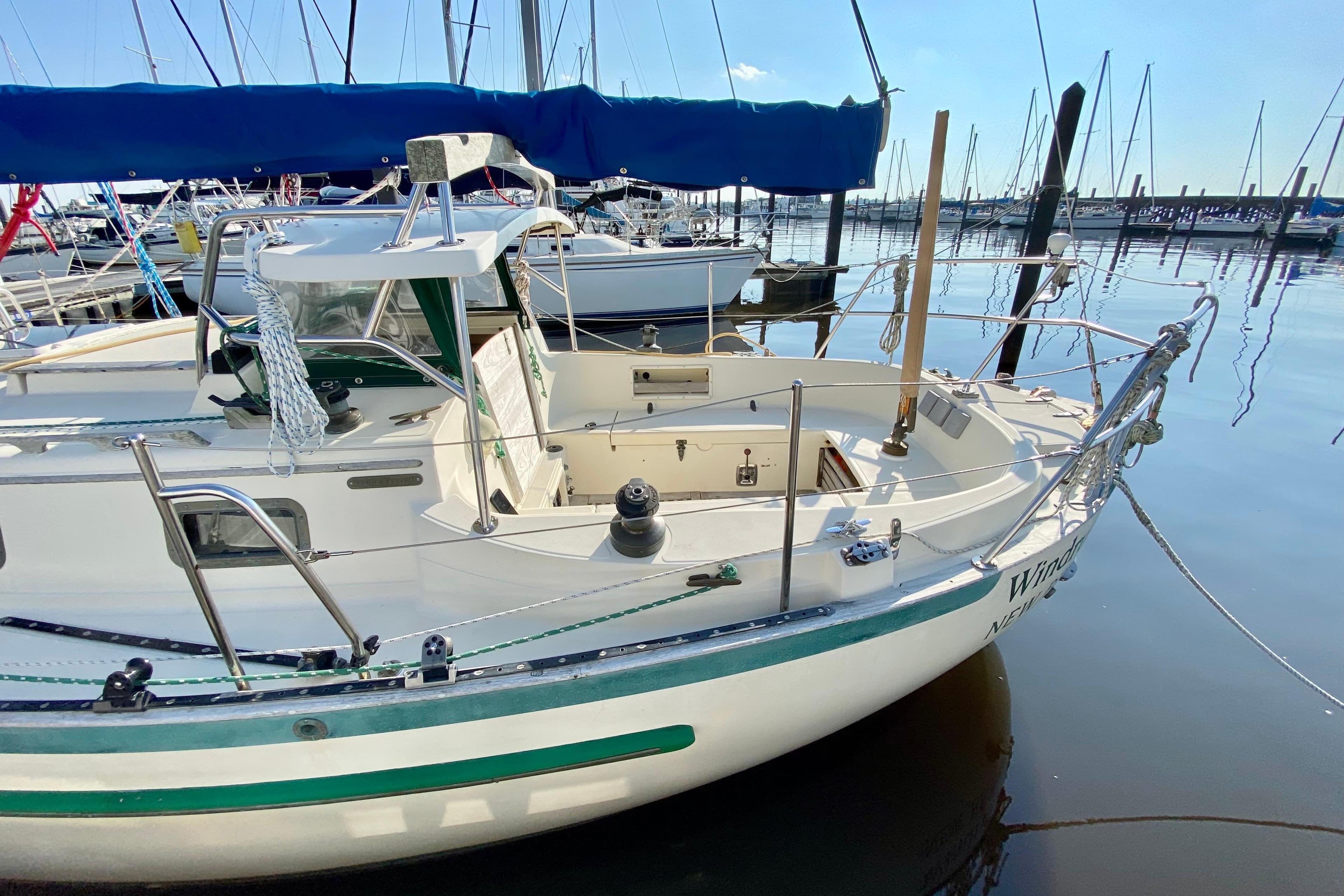 1993 Pacific Seacraft 34 sailboat docked in a marina, featuring a clean deck and blue canopy.