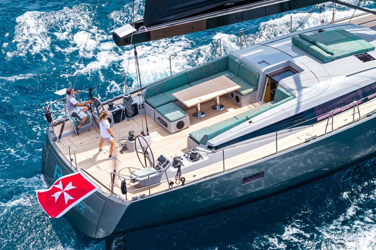 Luxurious 2016 CNB 76 yacht sailing on blue ocean with elegant deck and seating area.