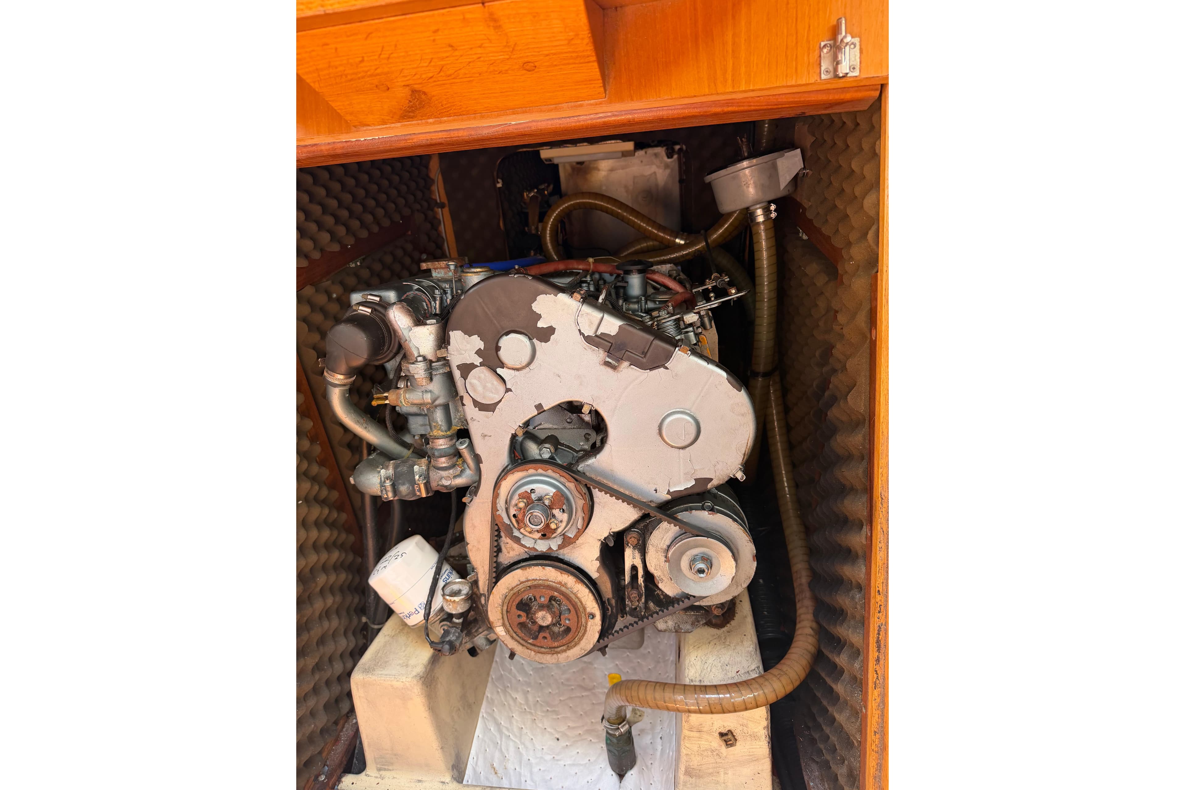 Engine compartment of a 1990 Beneteau Oceanis 430 sailboat, showcasing mechanical components.
