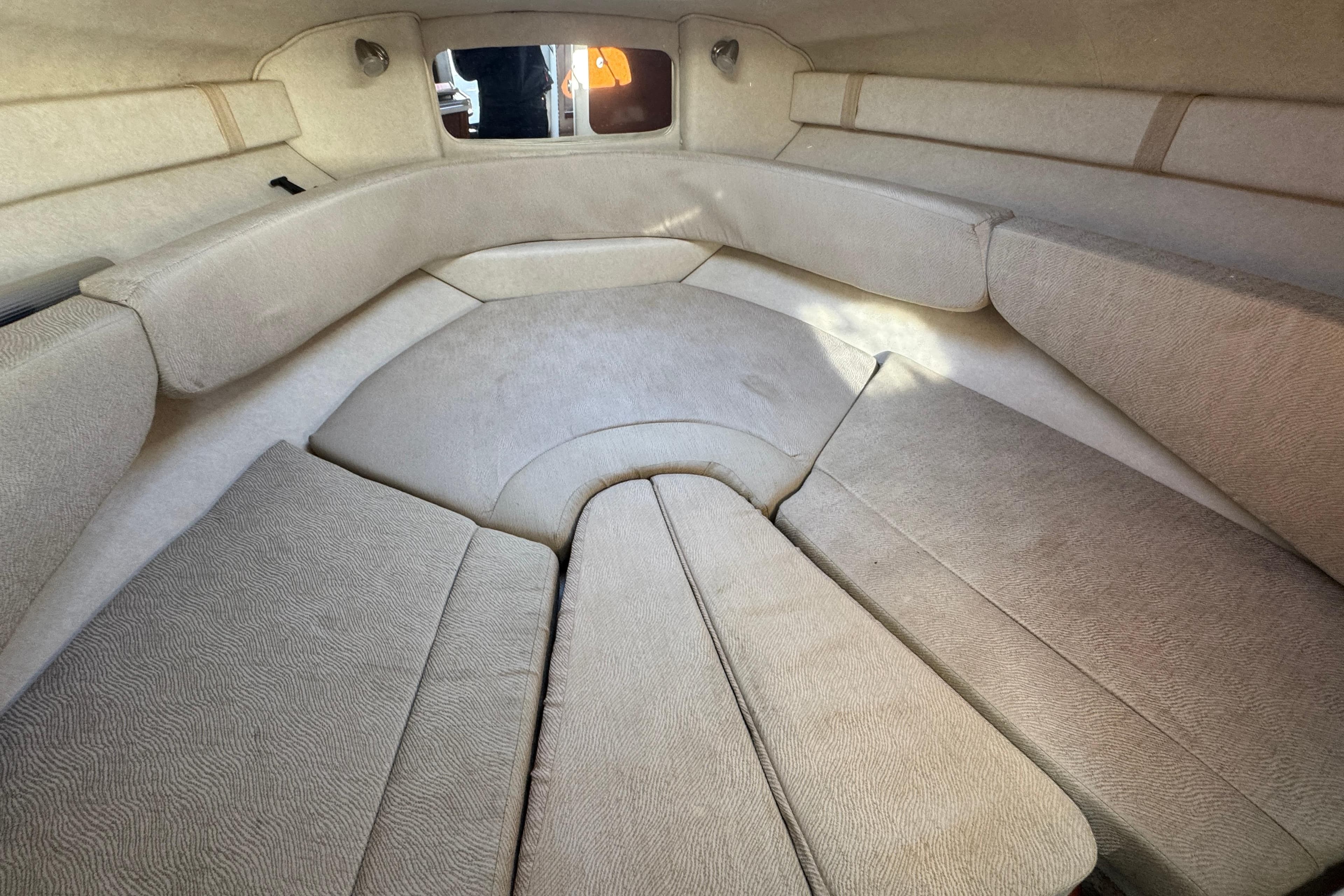 Interior cabin of 2008 Sea Ray 240 Sundancer with beige upholstery and seating.