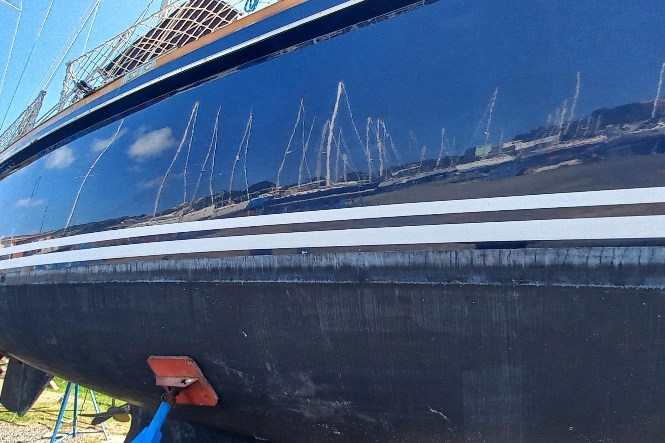 1974 Hinckley 49 sailboat hull with marina reflections.