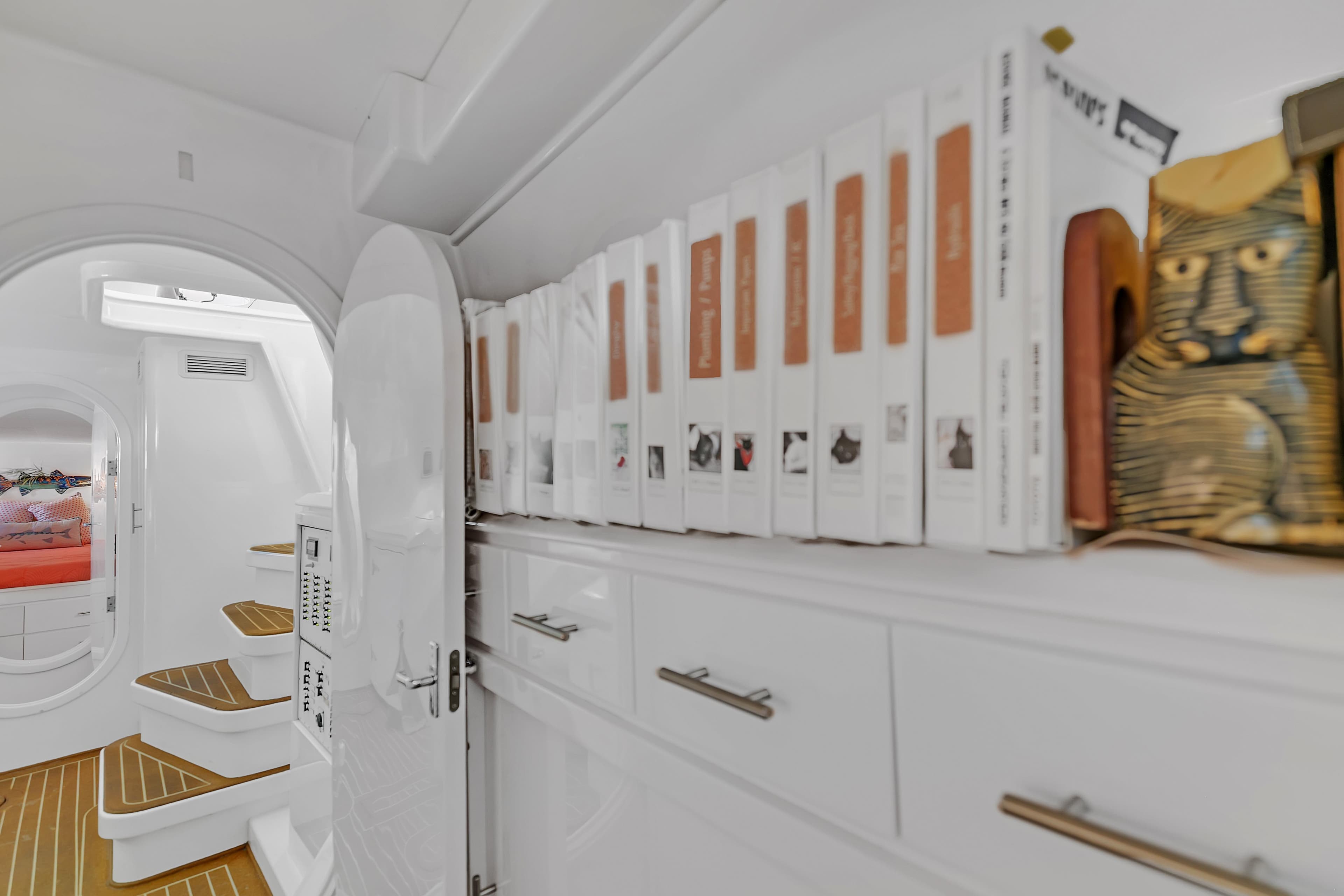 Interior of 1988 Kelsall Manannan Custom yacht with books and decorative items on shelves.