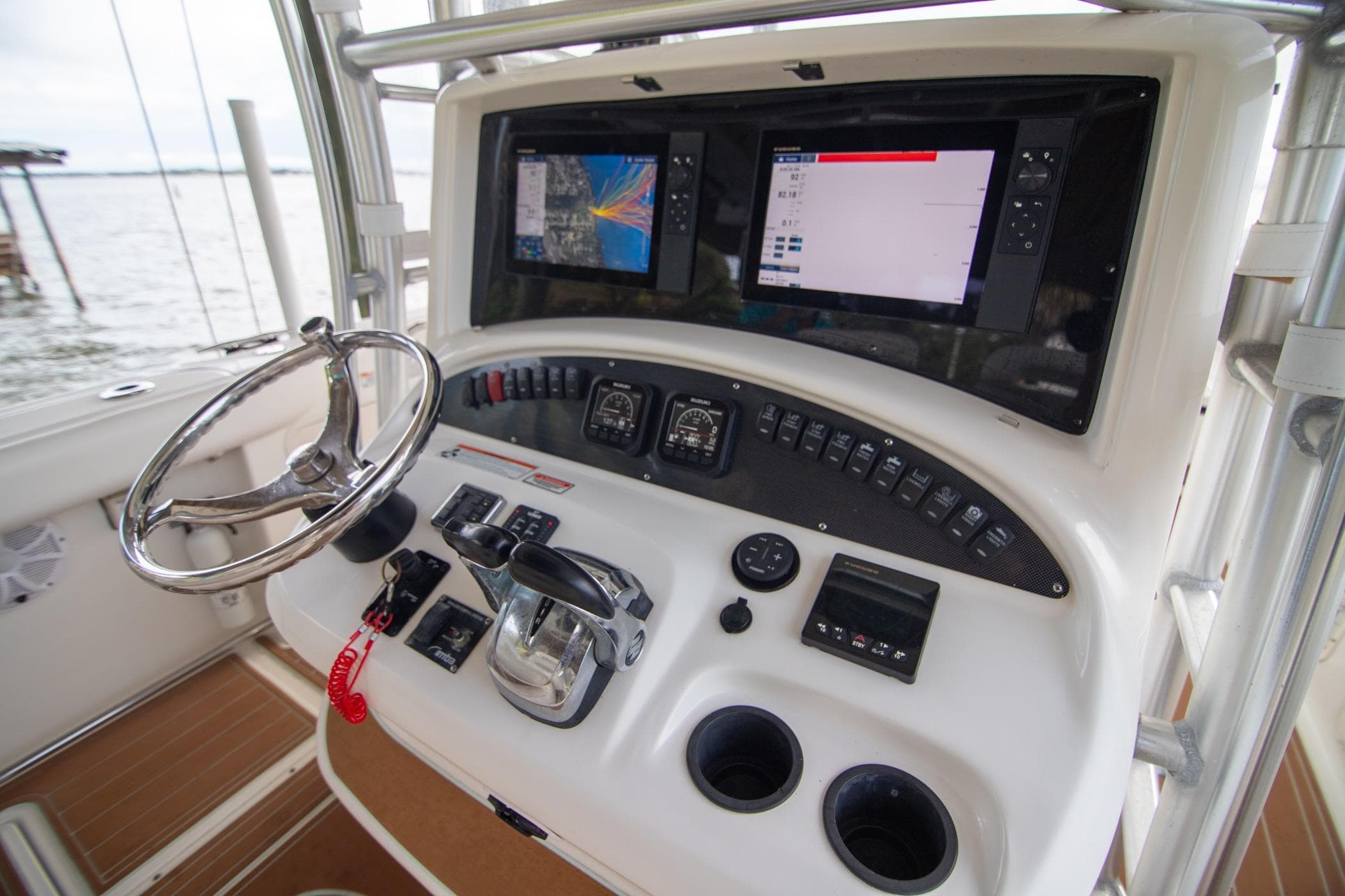 2006 Boston Whaler 320 Outrage helm with dual displays and steering wheel.