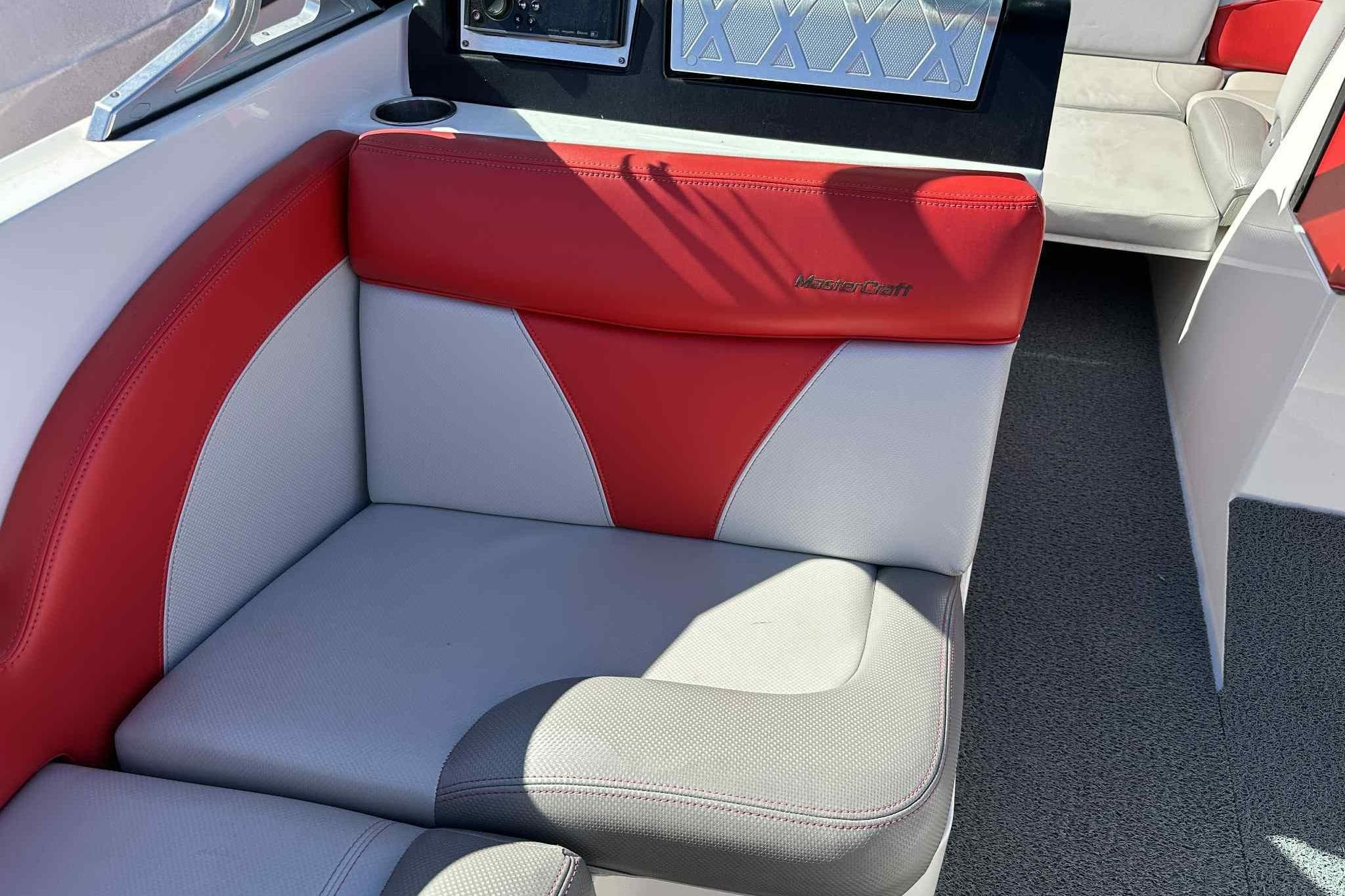 2016 MasterCraft X23 boat interior with red and gray seating, showcasing luxury design.