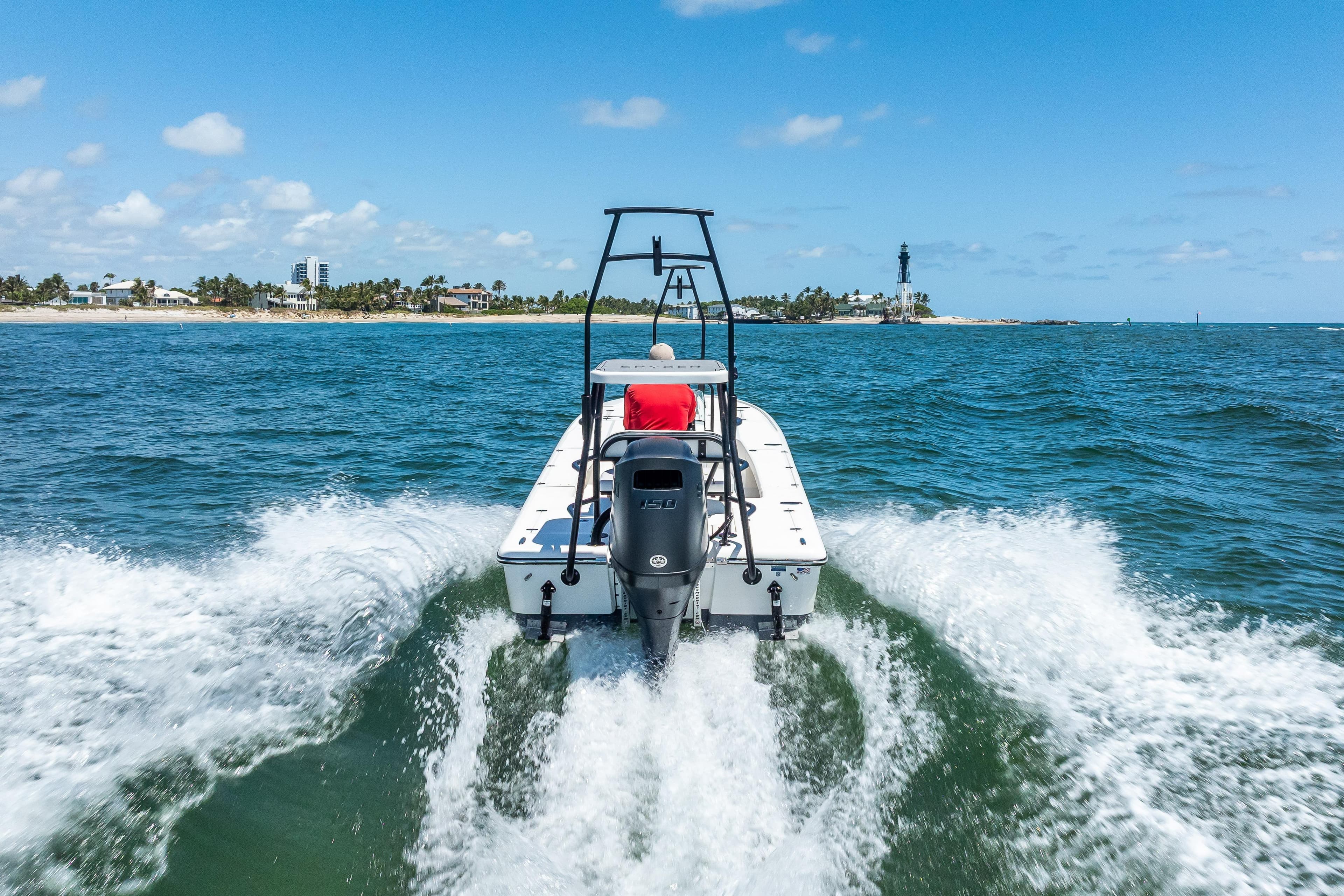 Spyder FX19 Vapor 2026 boat cruising near a scenic coastline with lighthouse.