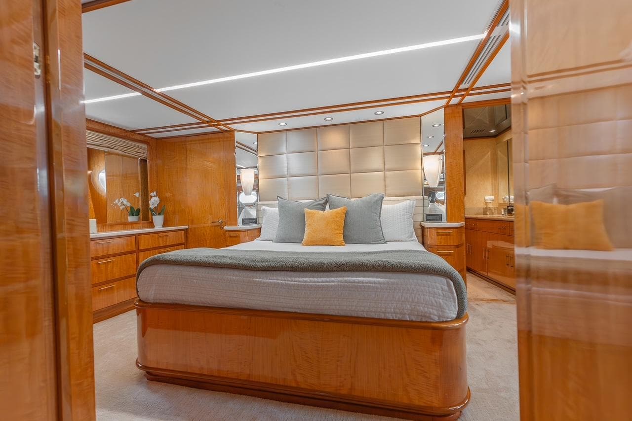 Luxurious bedroom interior on 2001 Intermarine RPH 95 yacht with elegant wood finishes.