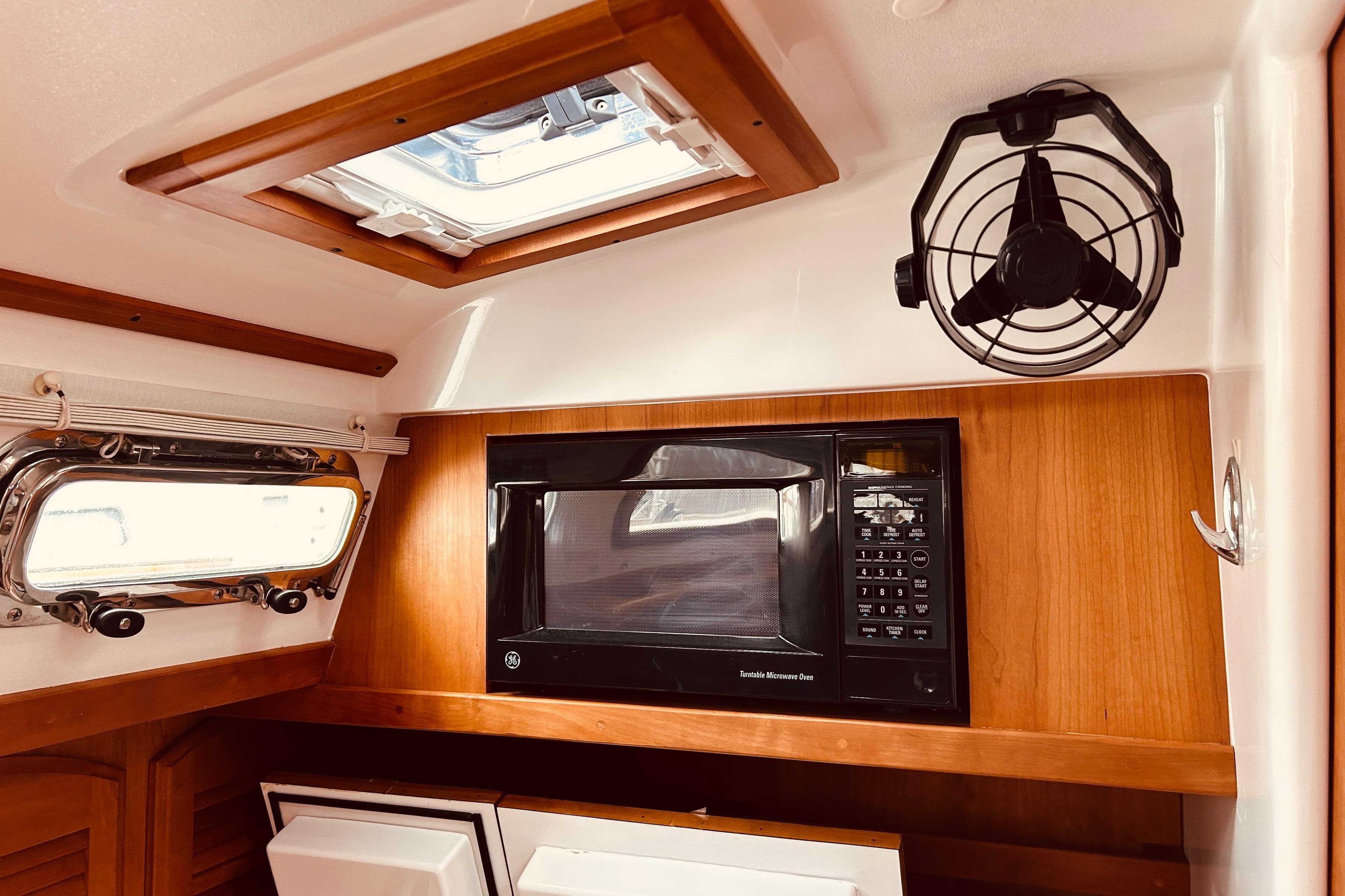 2004 Sabre 426 yacht interior with microwave, fan, and porthole window.