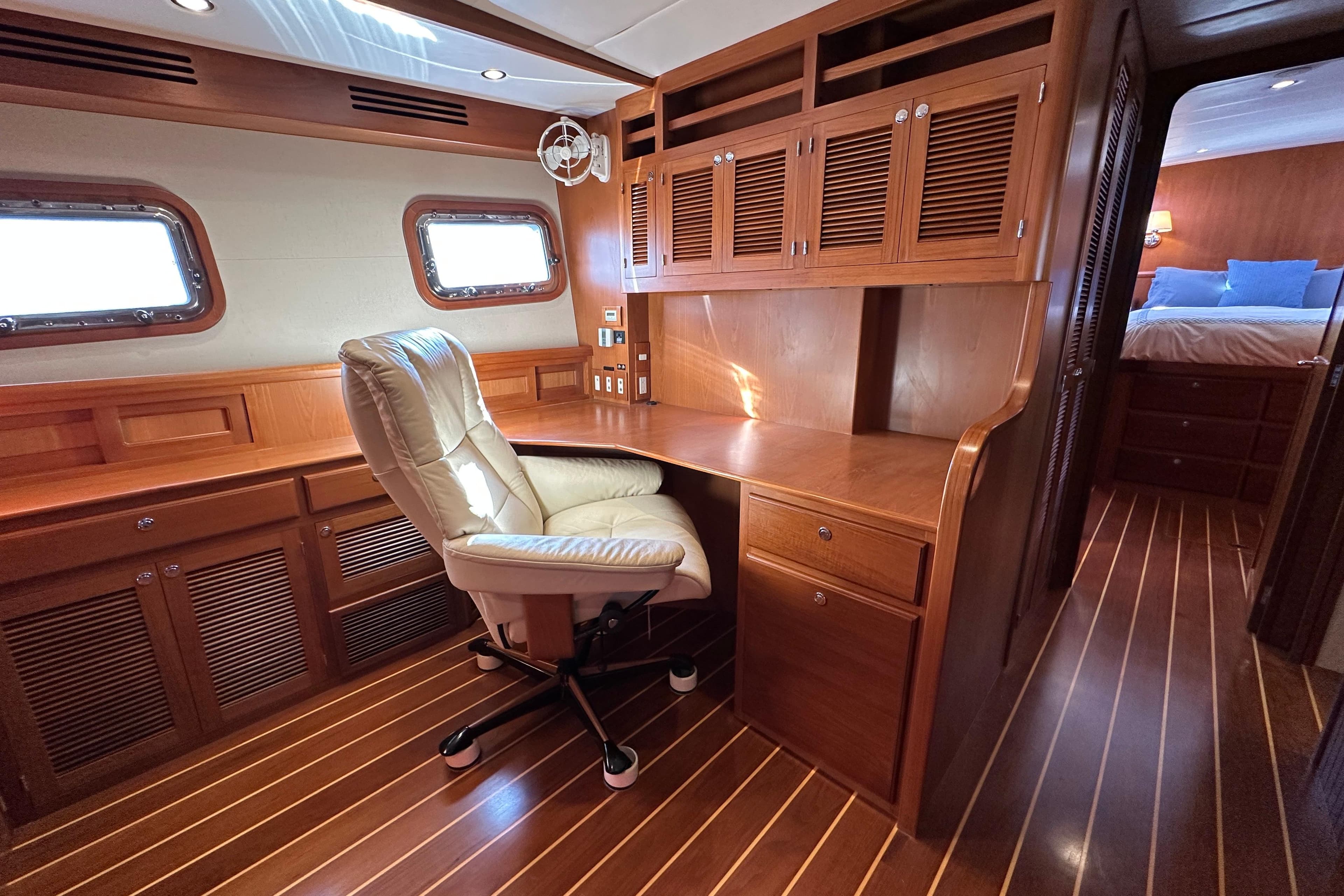 Luxurious wooden interior of 2017 Kadey-Krogen 58EB yacht with desk and chair.