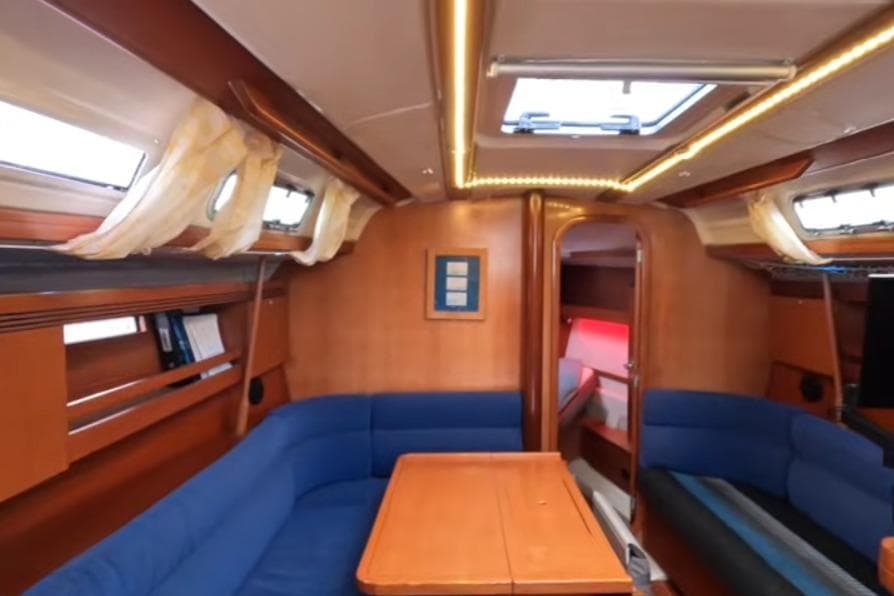 Interior of 2003 Dufour 40 Performance yacht with blue seating and wooden finishes.