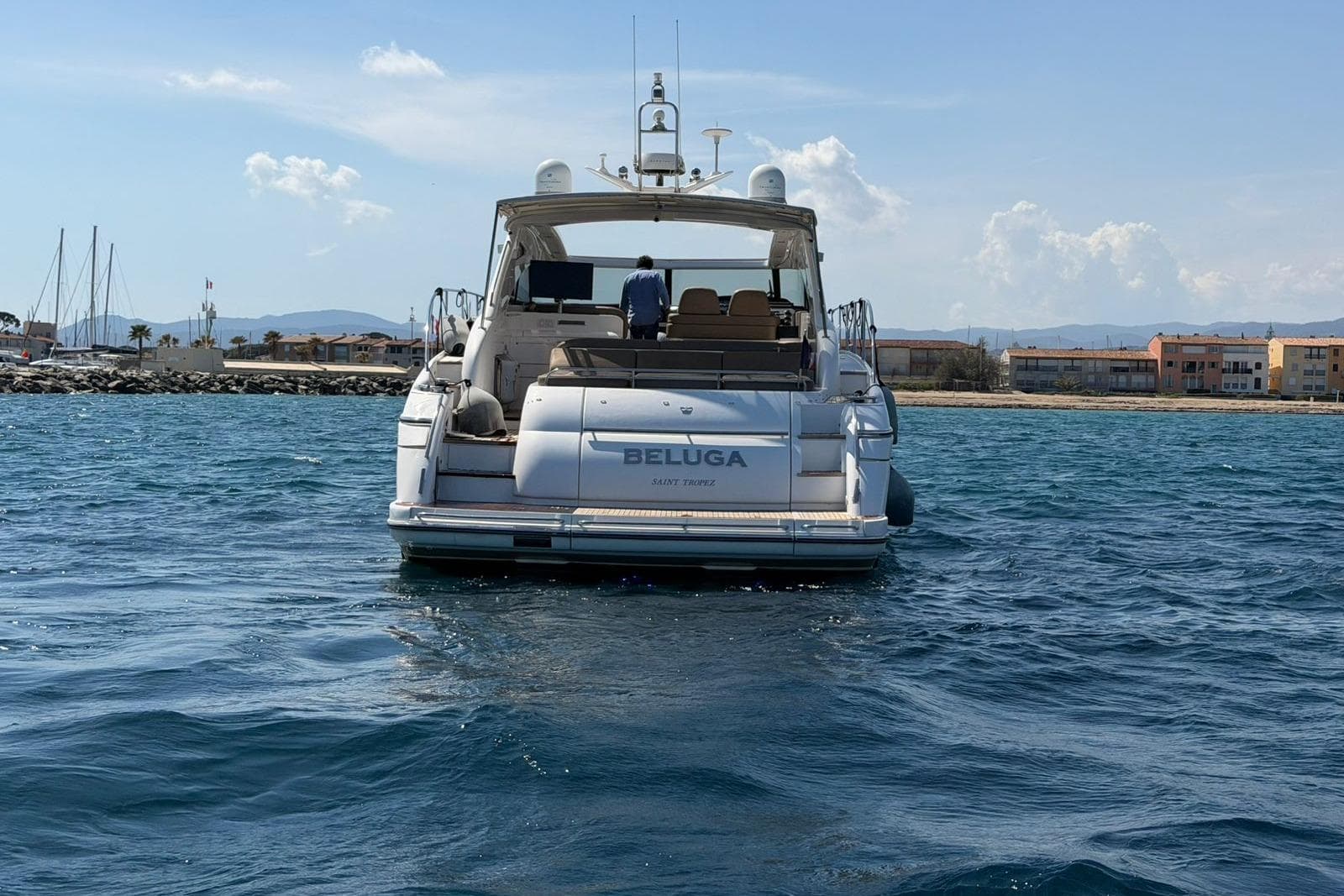 2003 Princess V58 yacht named "Beluga" on calm waters near a coastal town.