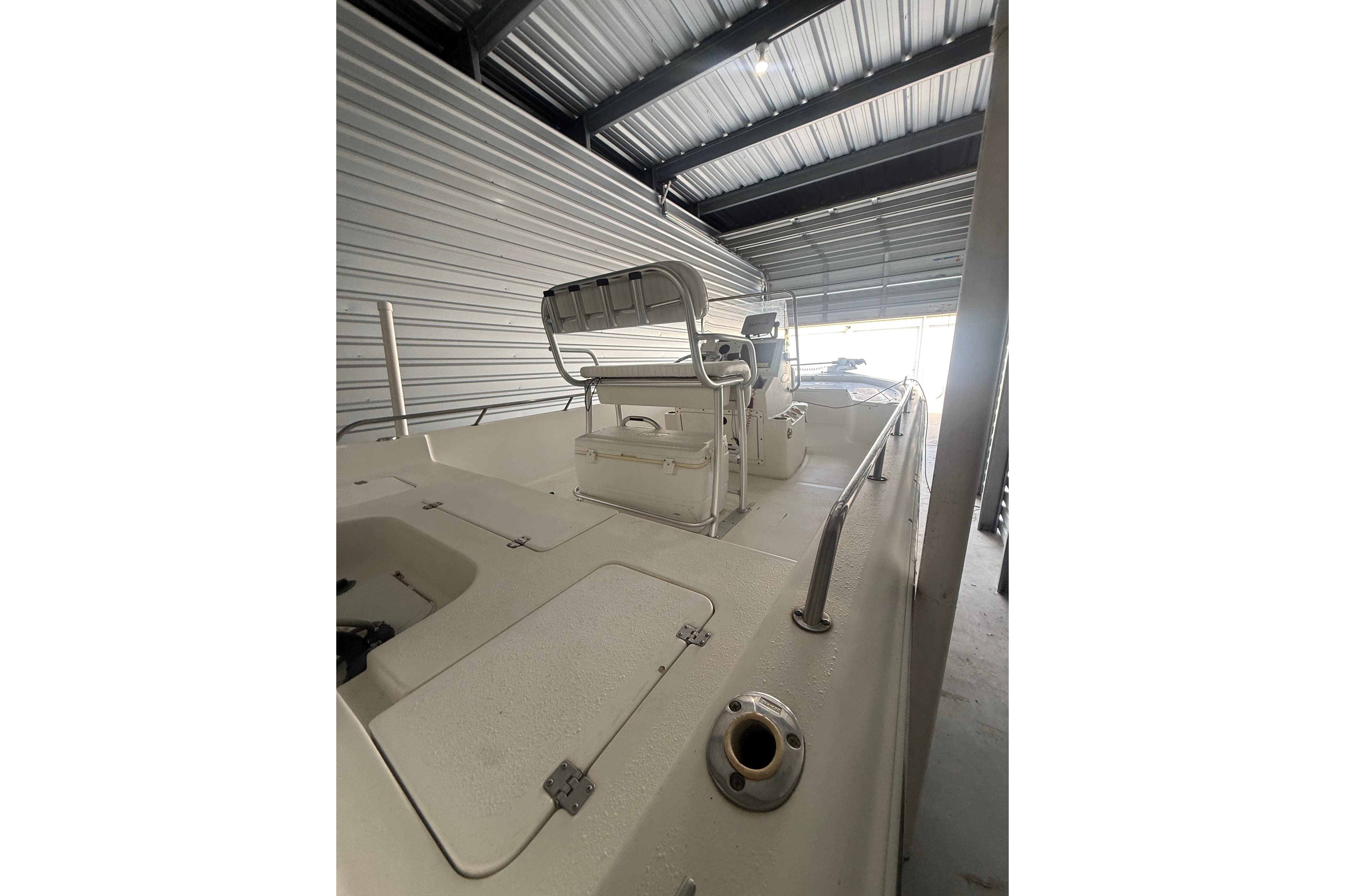 2005 Sea Pro SV2400CC Bay Boat in storage, showcasing spacious deck and helm.