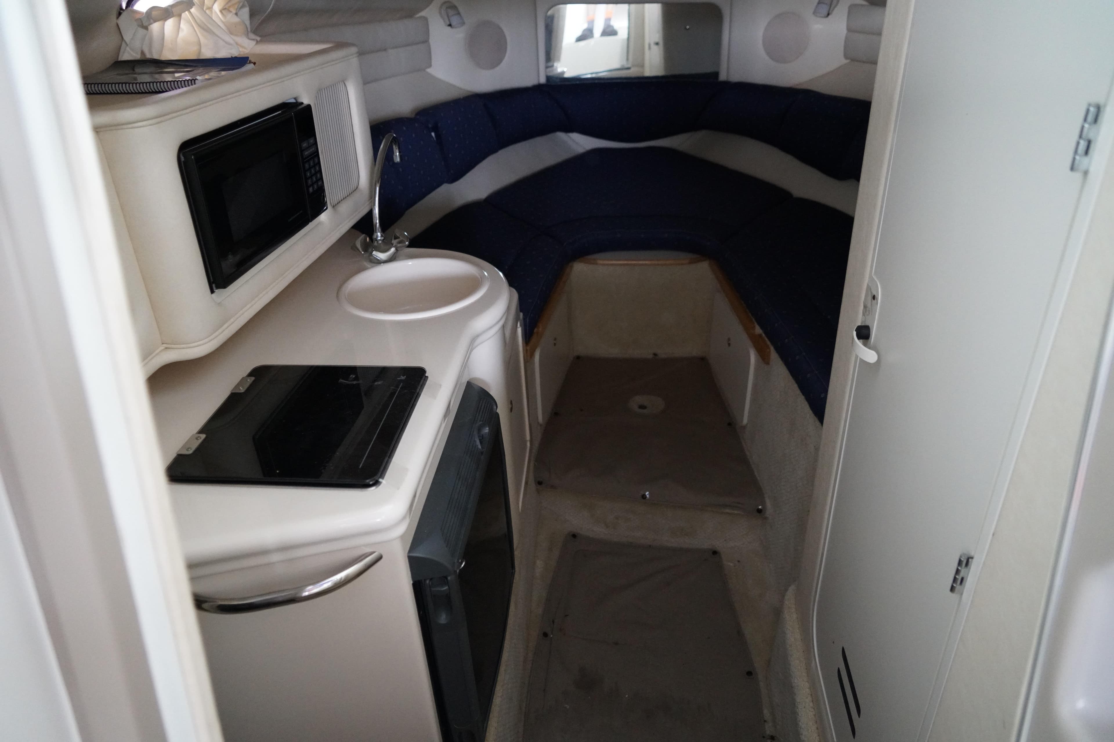 Interior of 2002 Sea Ray Sundancer 260 boat with kitchenette and seating area.