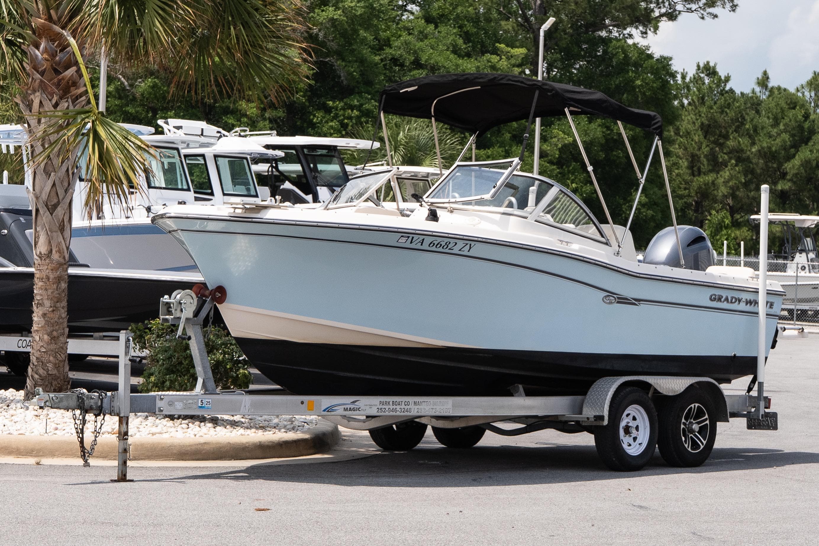 2017 Grady-White Freedom 205 boat on trailer, parked near palm tree.