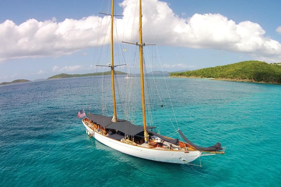 Vintage 1939 William McMeek Brooks Marine sailboat on turquoise waters, under a clear sky.