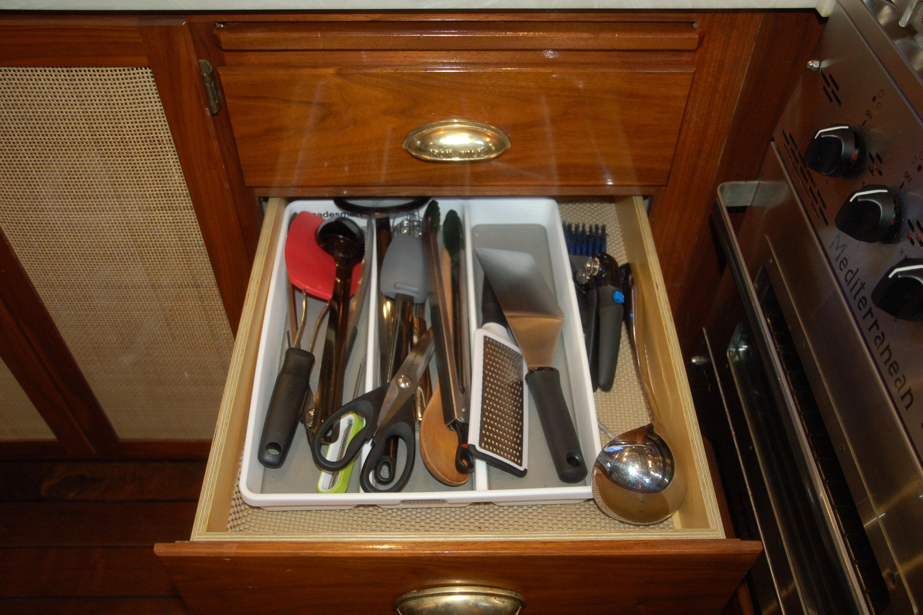 Kitchen drawer with assorted utensils in a 2006 Custom Sprague model.