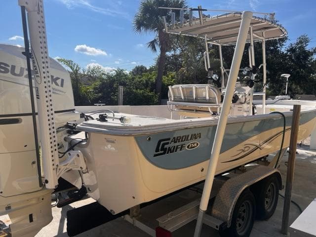 2019 Carolina Skiff 258 DLV boat on trailer with Suzuki outboard motor.