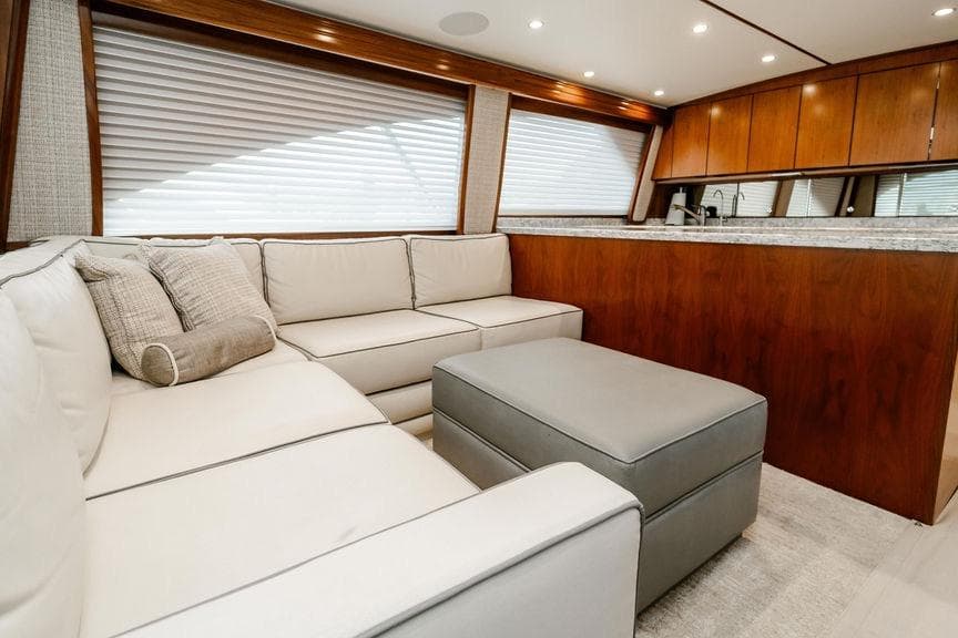 Luxurious interior of 2021 Viking 58 Convertible yacht with plush seating and elegant wood finishes.