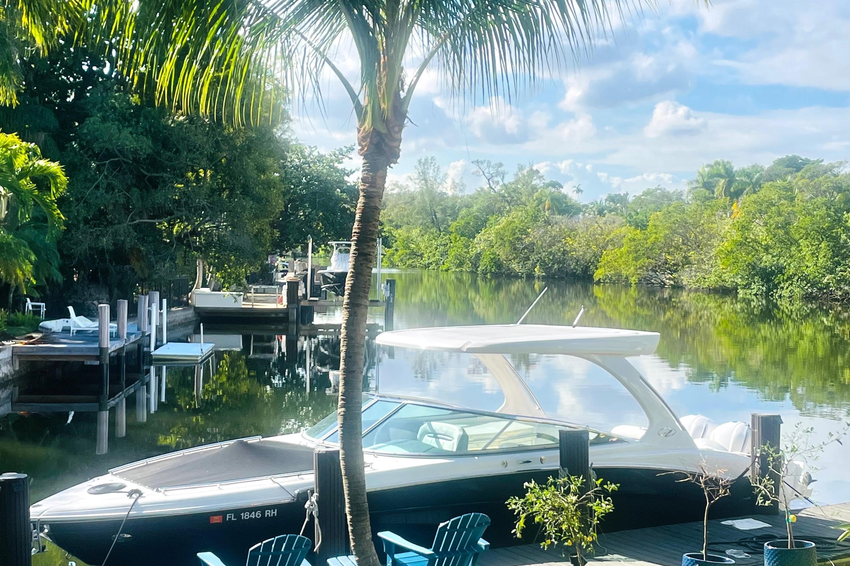 2017 Regal 33 OBX boat docked by a serene, lush riverside.