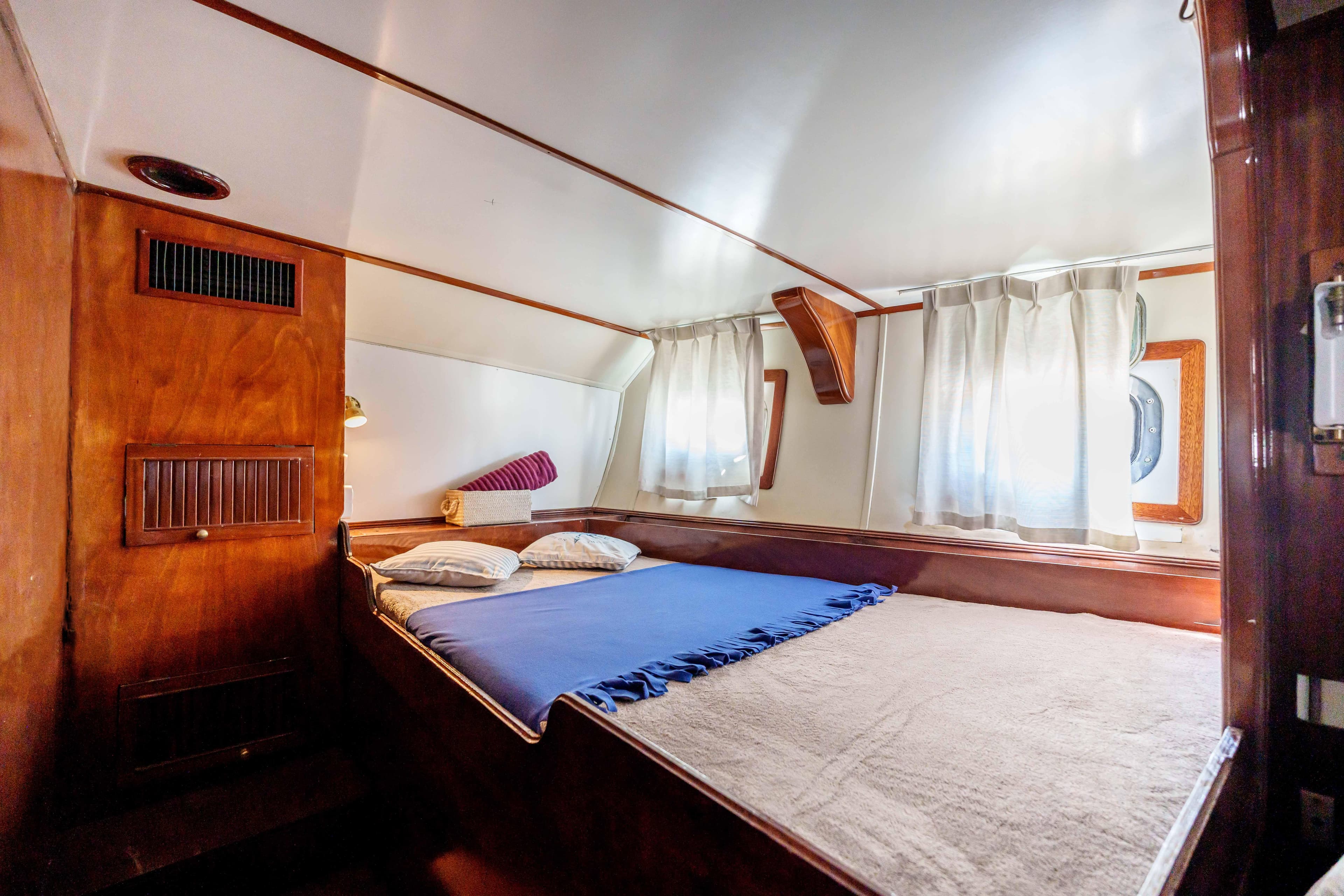 Cozy cabin interior of 1983 Cavalier 92 yacht with bed and wooden accents.