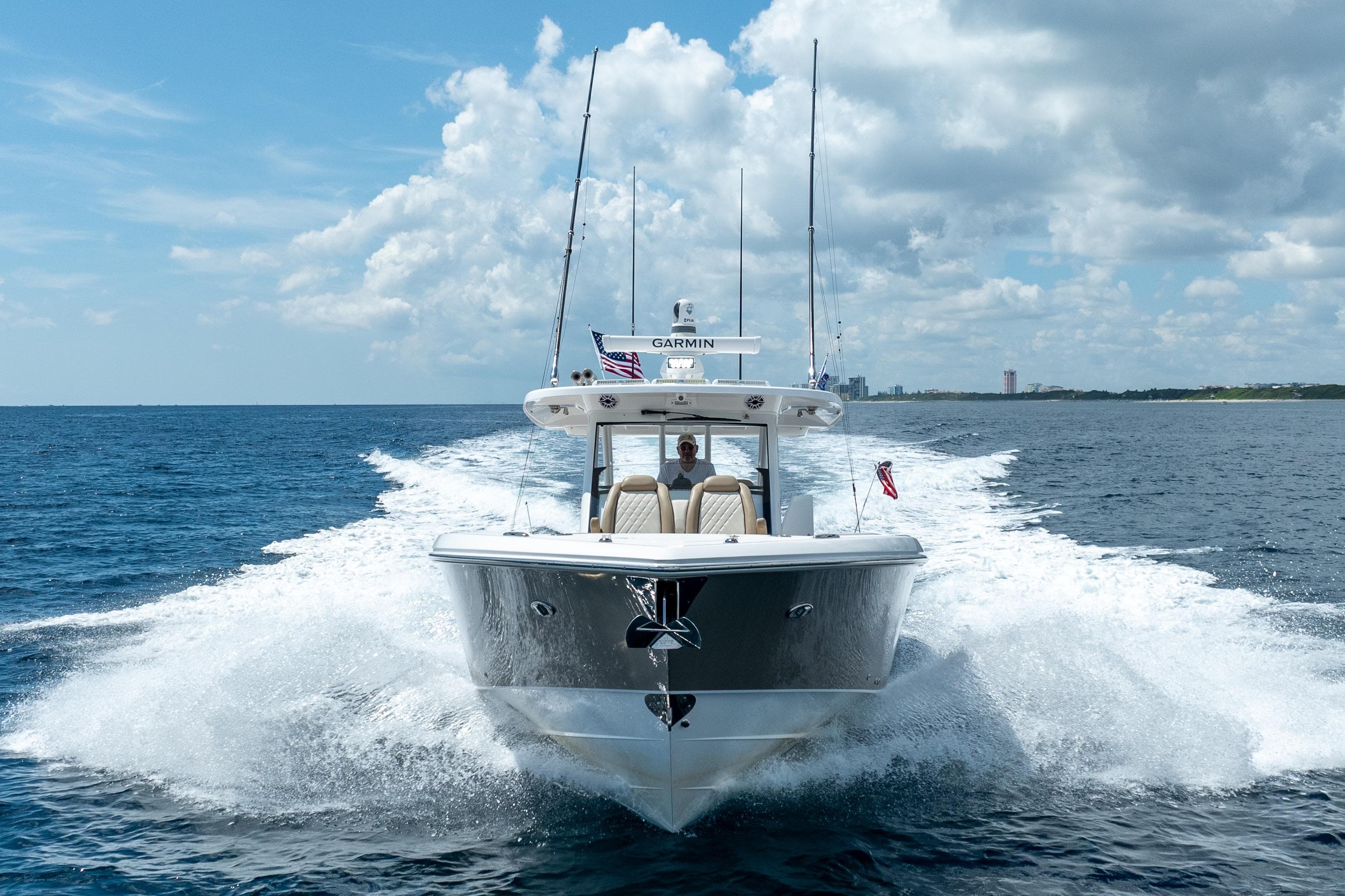 2021 Everglades 395 Center Console boat cruising on open water under a cloudy sky.