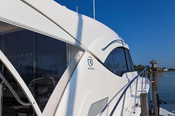 2016 Riviera 525 SUV yacht docked by calm waters.