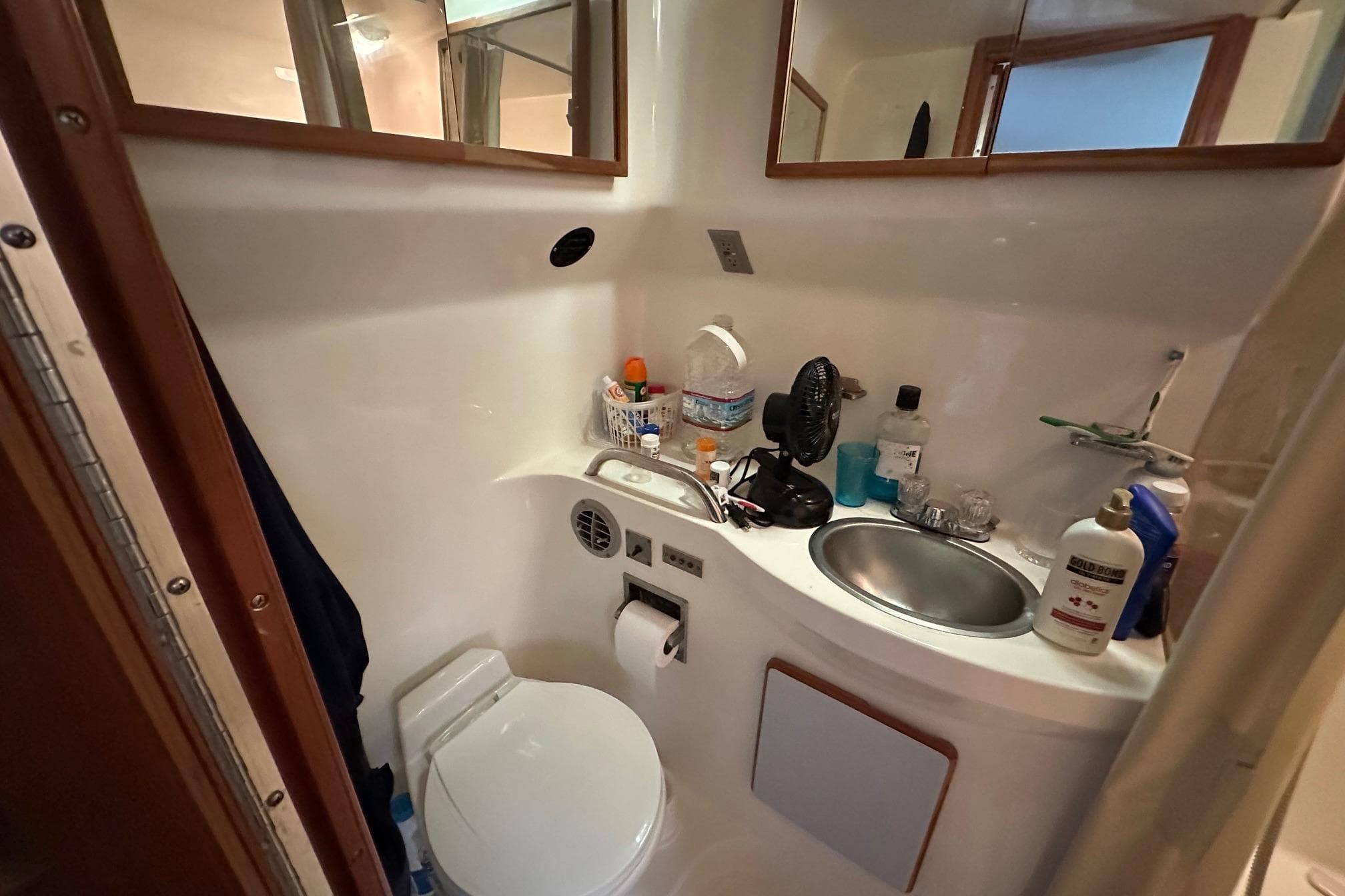 Compact bathroom in 1989 Sea Ray 380 Aft Cabin yacht, featuring sink and toilet.