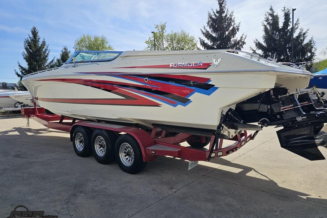 2001 Formula 382 FASTech boat on a red trailer, featuring vibrant graphics.