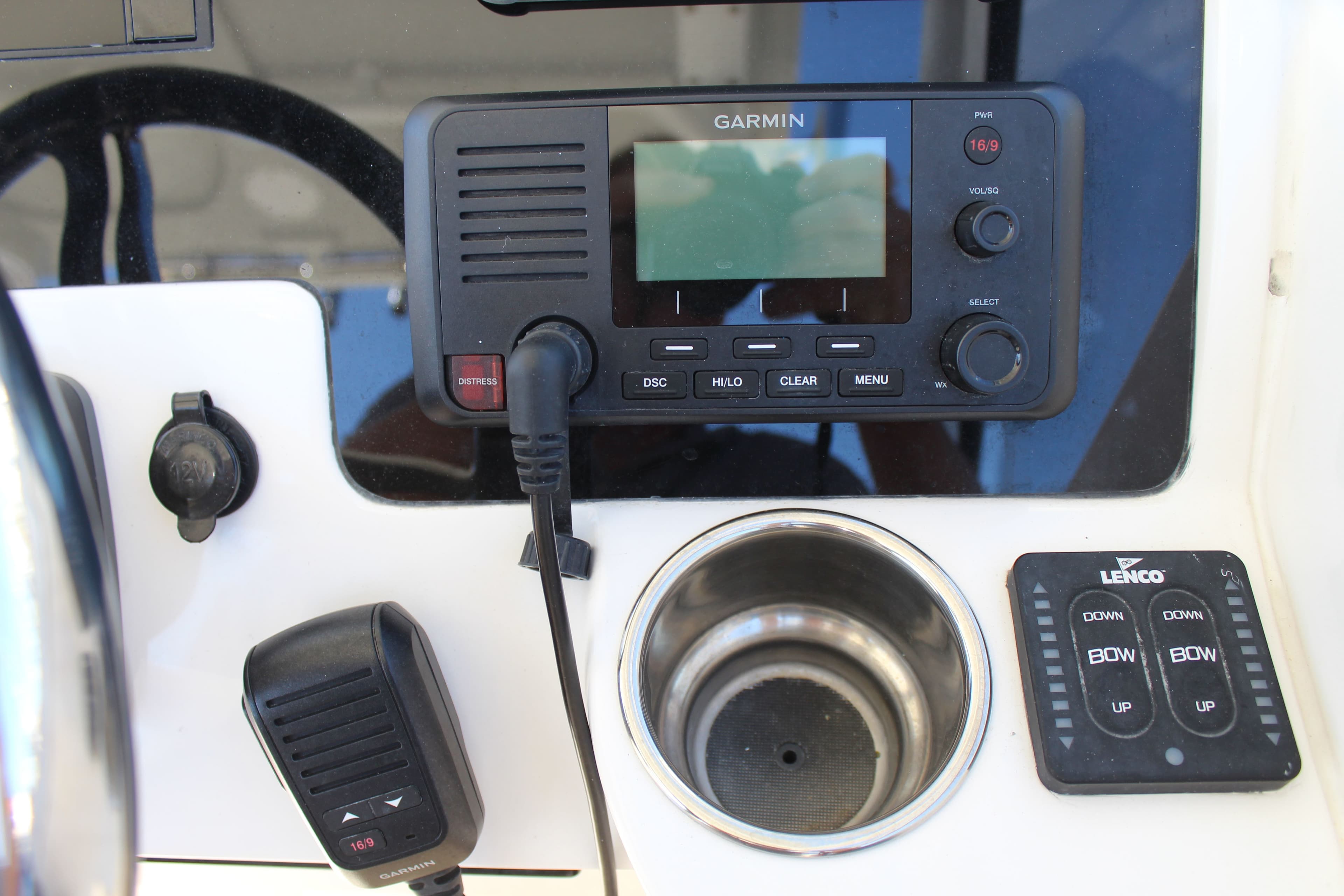 Control panel of 2020 Edgewater 248CX Crossover with Garmin radio and Lenco trim tab switches.