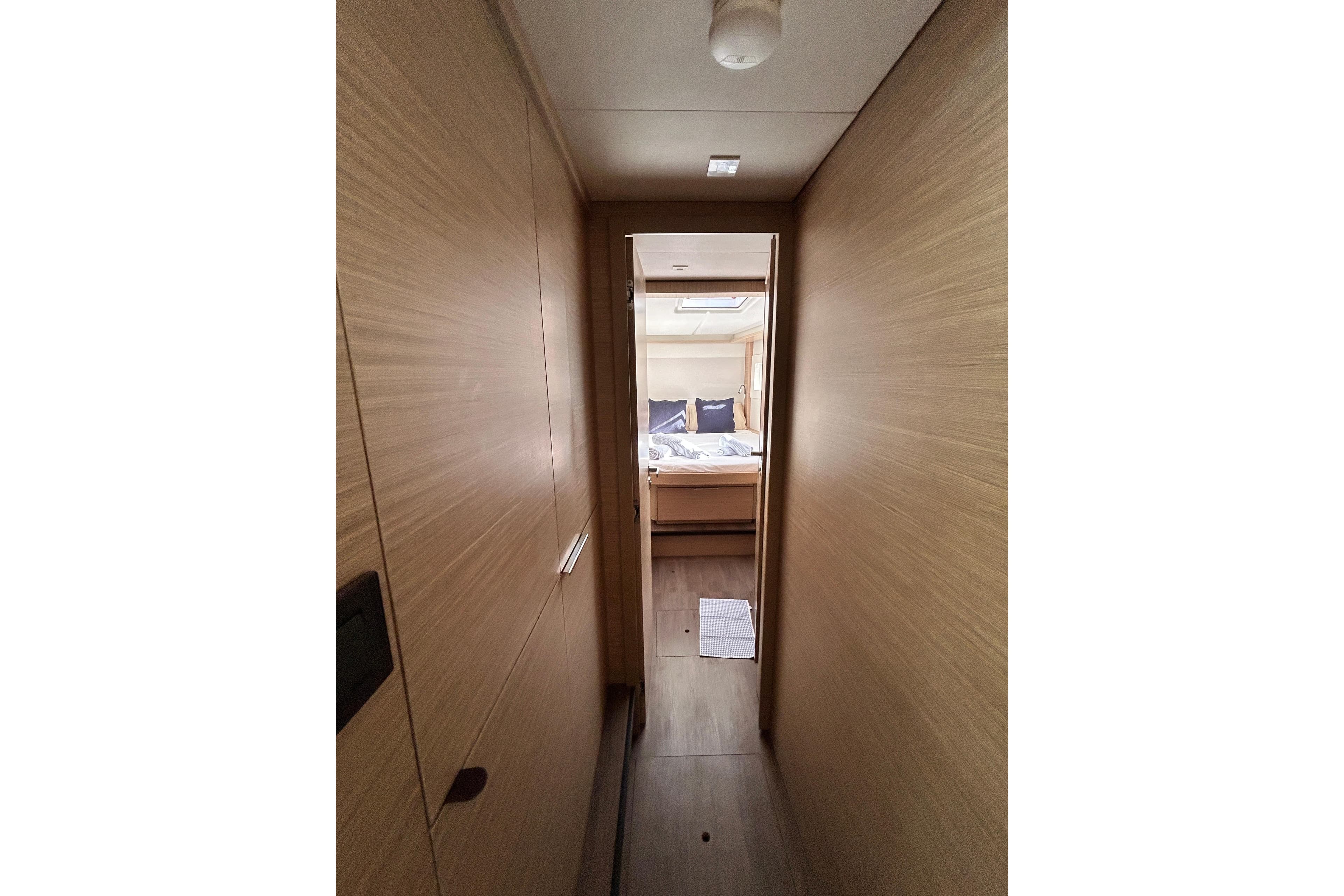 2024 Lagoon 46 yacht interior hallway leading to a cozy bedroom.
