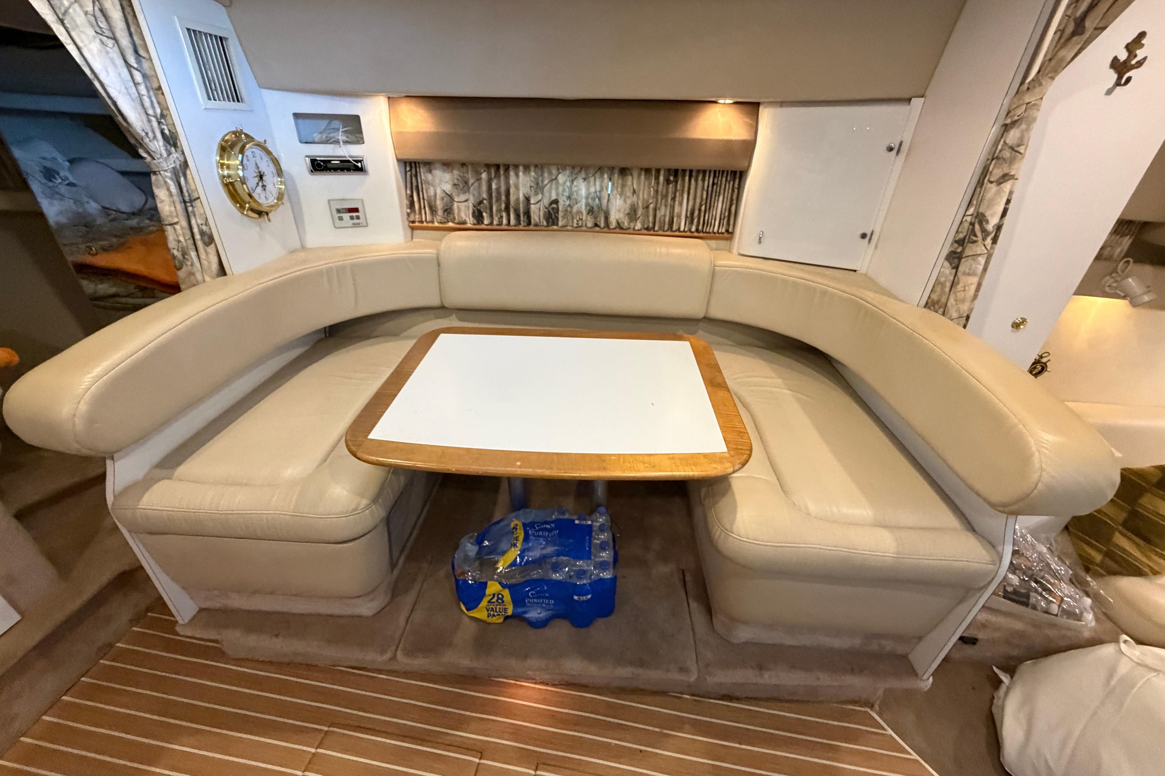 Interior of a 1998 Formula 34 Performance Cruiser with beige seating and a wooden table.